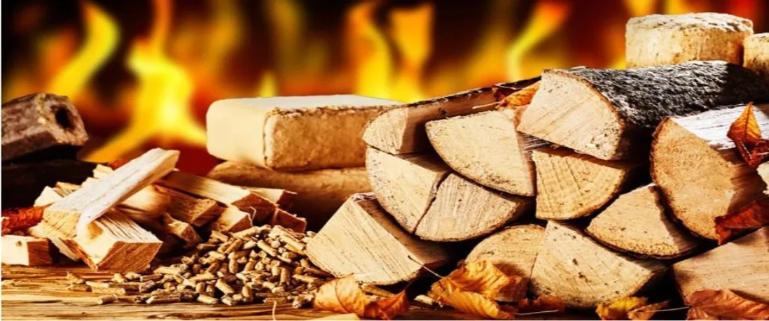 Bûches de bois empilées, avec des braises de feu en arrière-plan, prêtes pour un feu de cheminée.