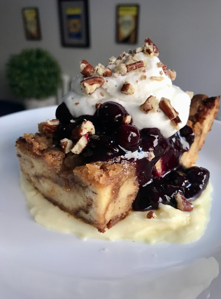 Croissant Bread Pudding with Pastry Cream, Blueberry Compote, Whipped Cream, and Toasted Pecans. 