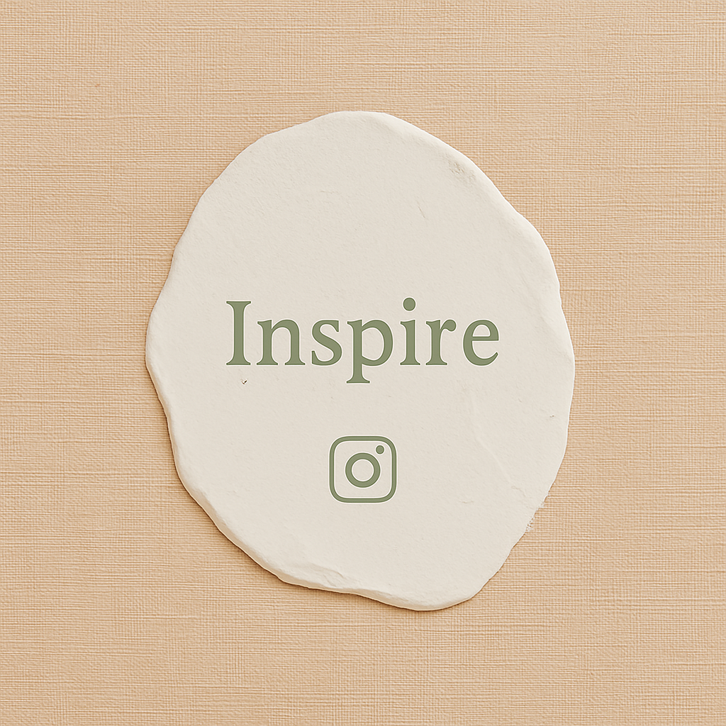 White stone with the word 'Inspire' and an Instagram logo printed on it, placed on a beige textured surface.