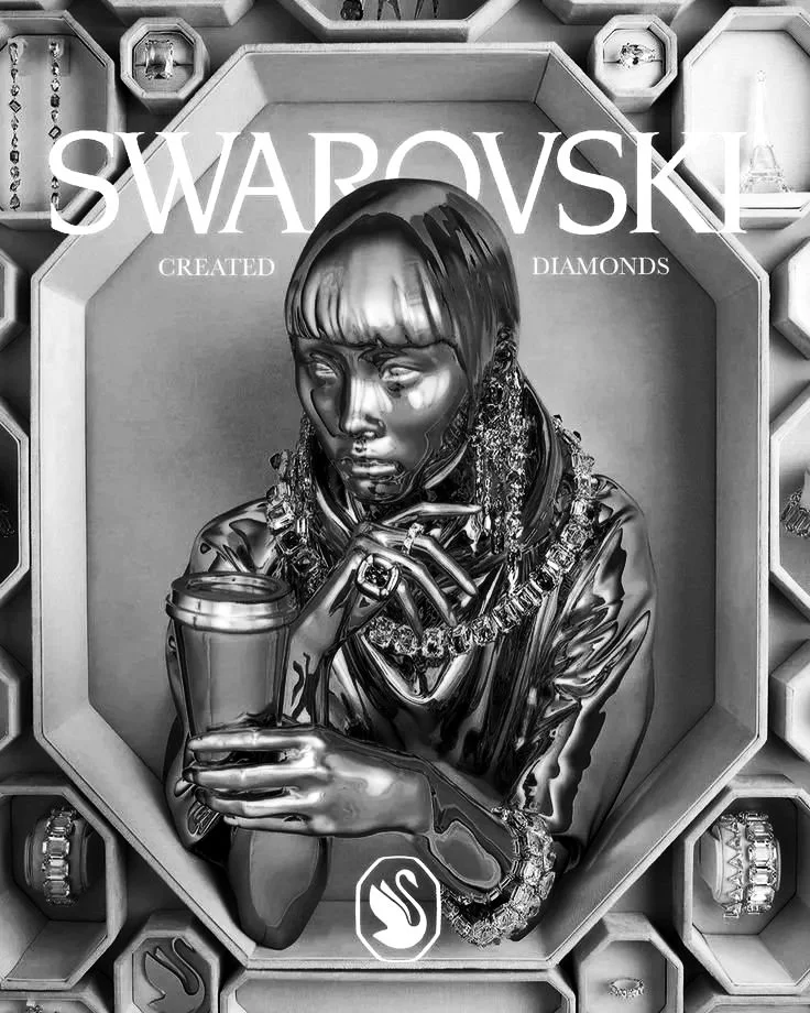 A metallic or chrome-finished sculpture of a woman with a short bob haircut, holding a coffee cup, wearing multiple jewelry pieces, surrounded by display boxes of Swarovski diamonds in a display case.