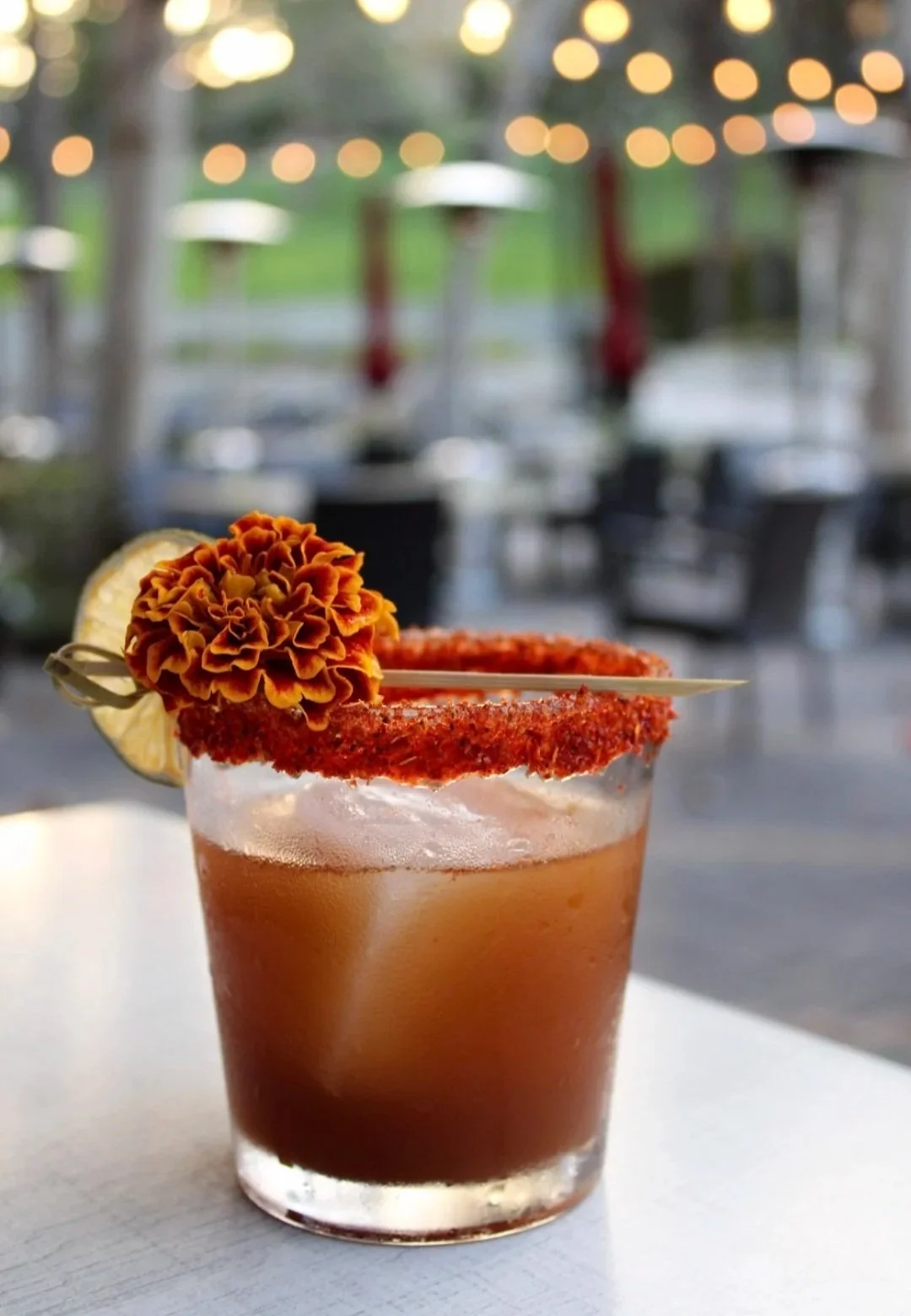 Fire & Bloom: This delicious mezcal creation blends the tang of tamarind, the warmth of chipotle and the brightness of lime - crowned with a vibrant chamoy tajin rim.