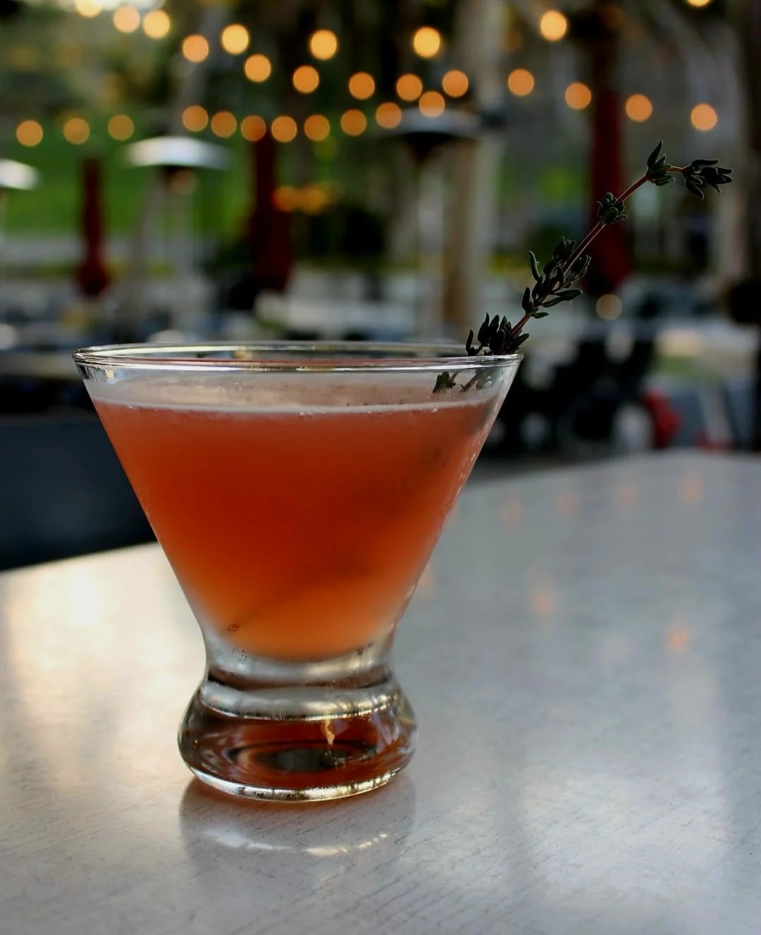 Blood Moon: This striking martini layers crisp botanical gin with vibrant blood orange liqueur, the bittersweet depth of Amaro Nonino, and a touch of lemon, topped with a splash of sparkling blood orange juice and finished with a fragrant thyme sprig