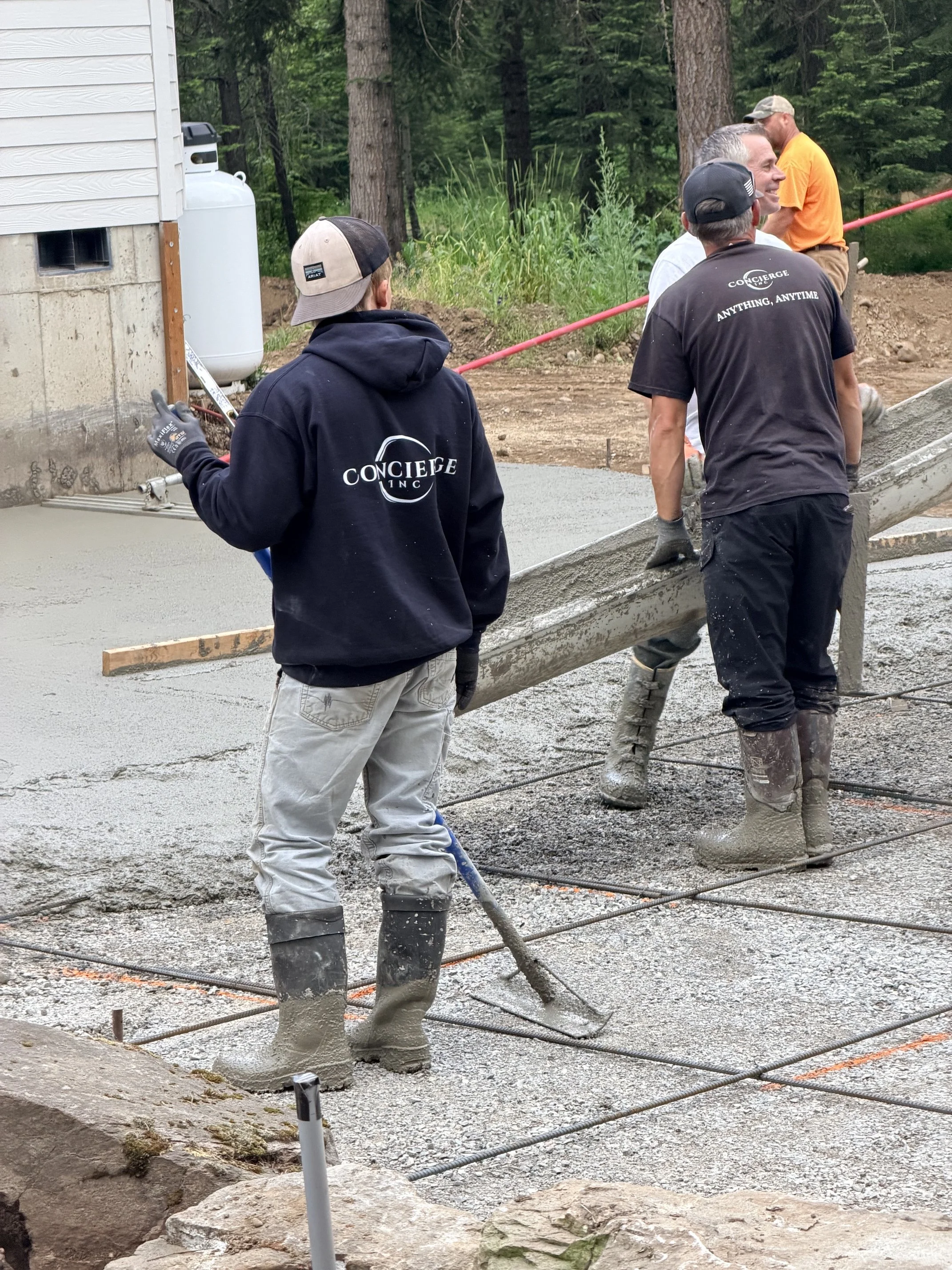 Concierge crew working to pour concrete for custom home's outdoor living space