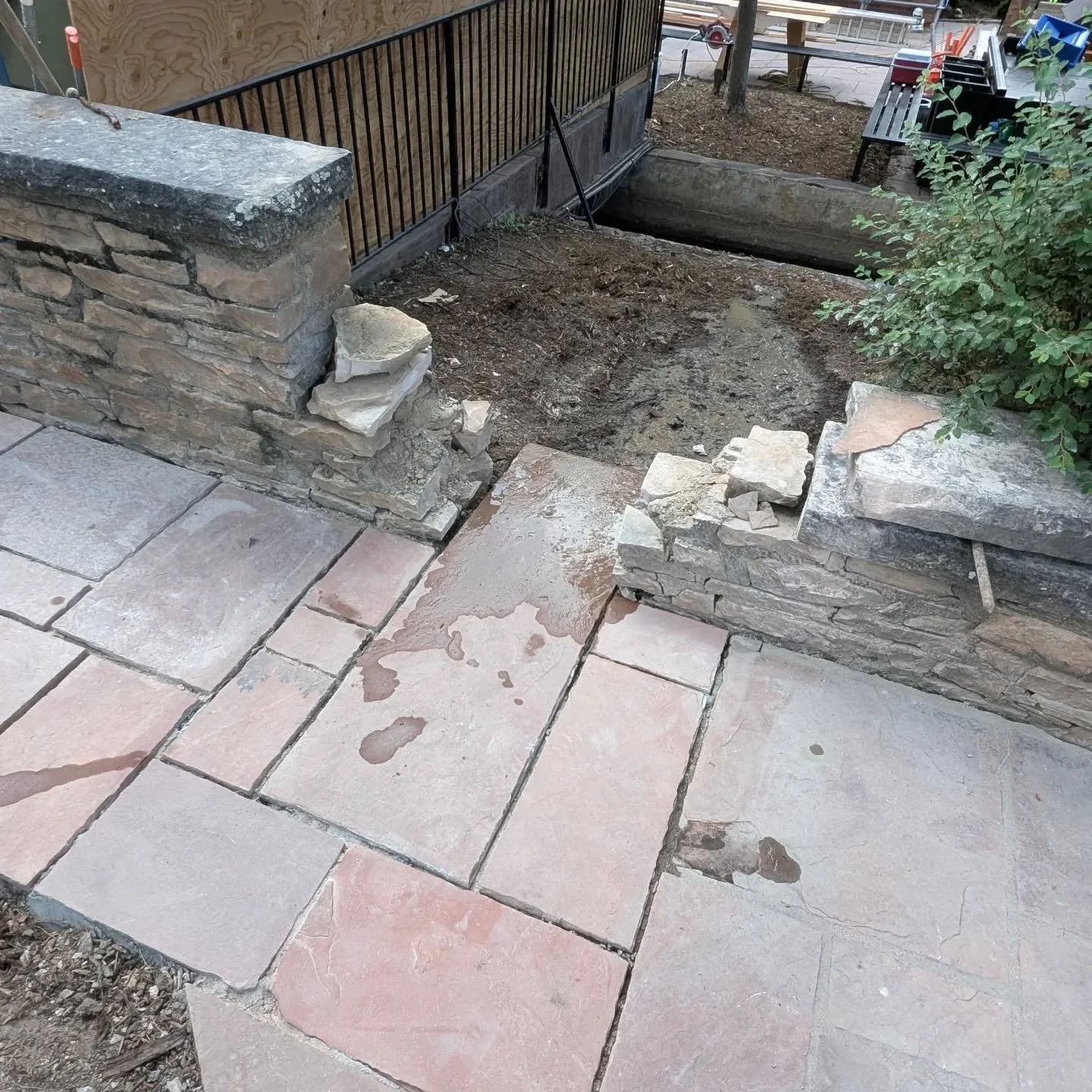 This pathway was falling apart and water was causing destruction on the foundation and stomework. Once the stone was pulled up and much was reclaimed, a concrete pad was poured and the stone was mortar set. We put some water mitigation features into 