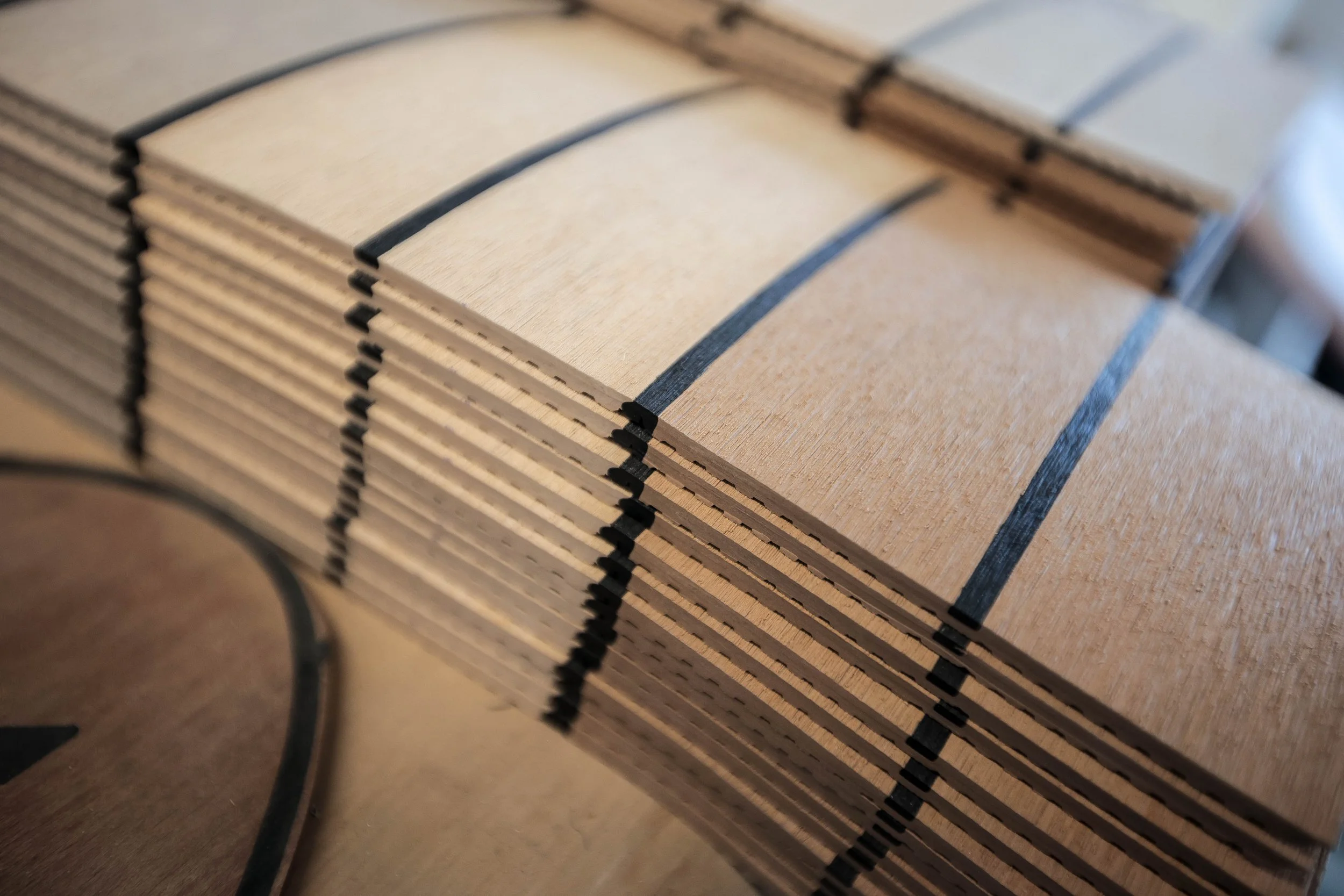 Stacked sheets of cardboard with black stripes along the edges.