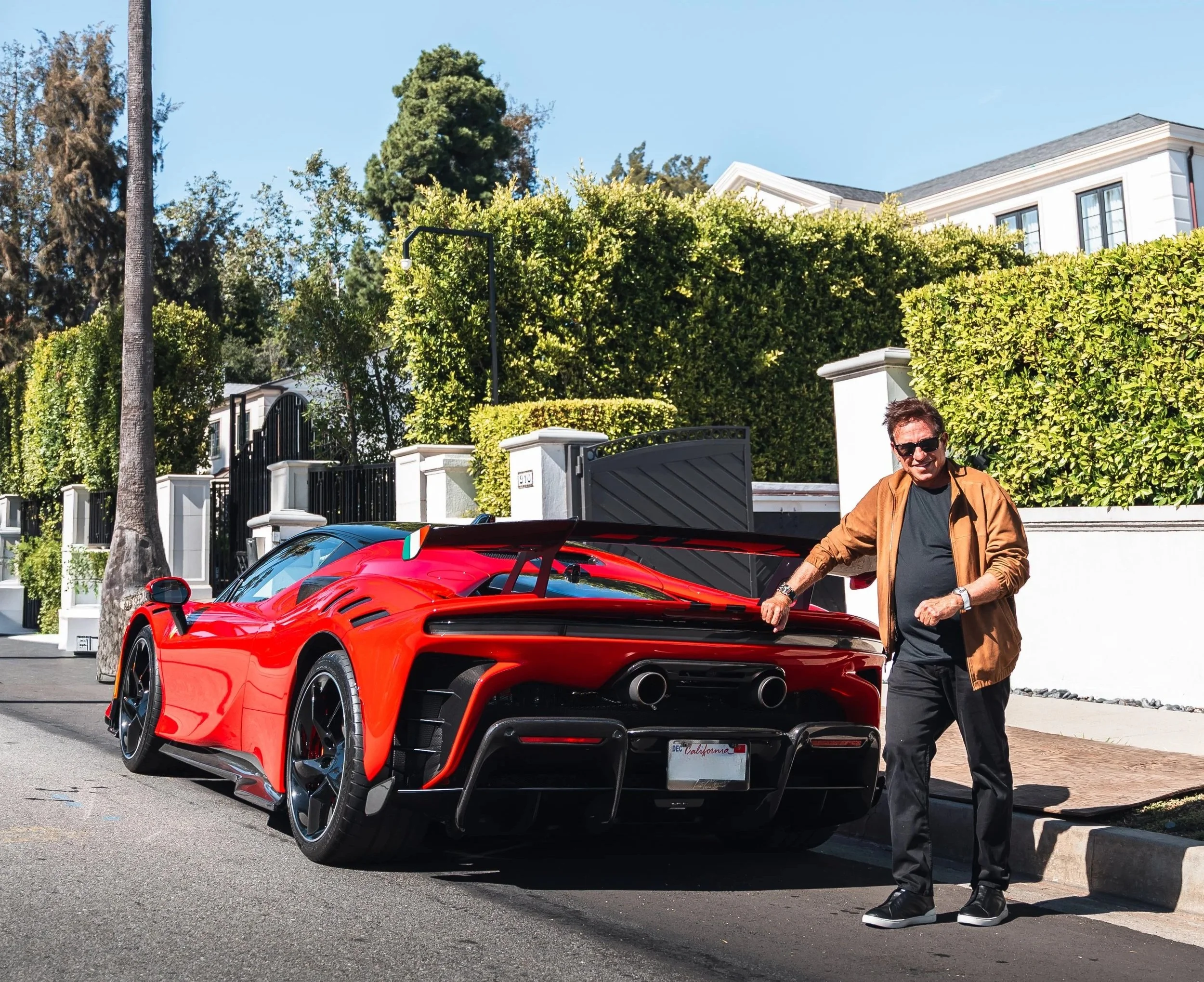 Marc Menowitz standing next to a red Ferrari SF90 XX