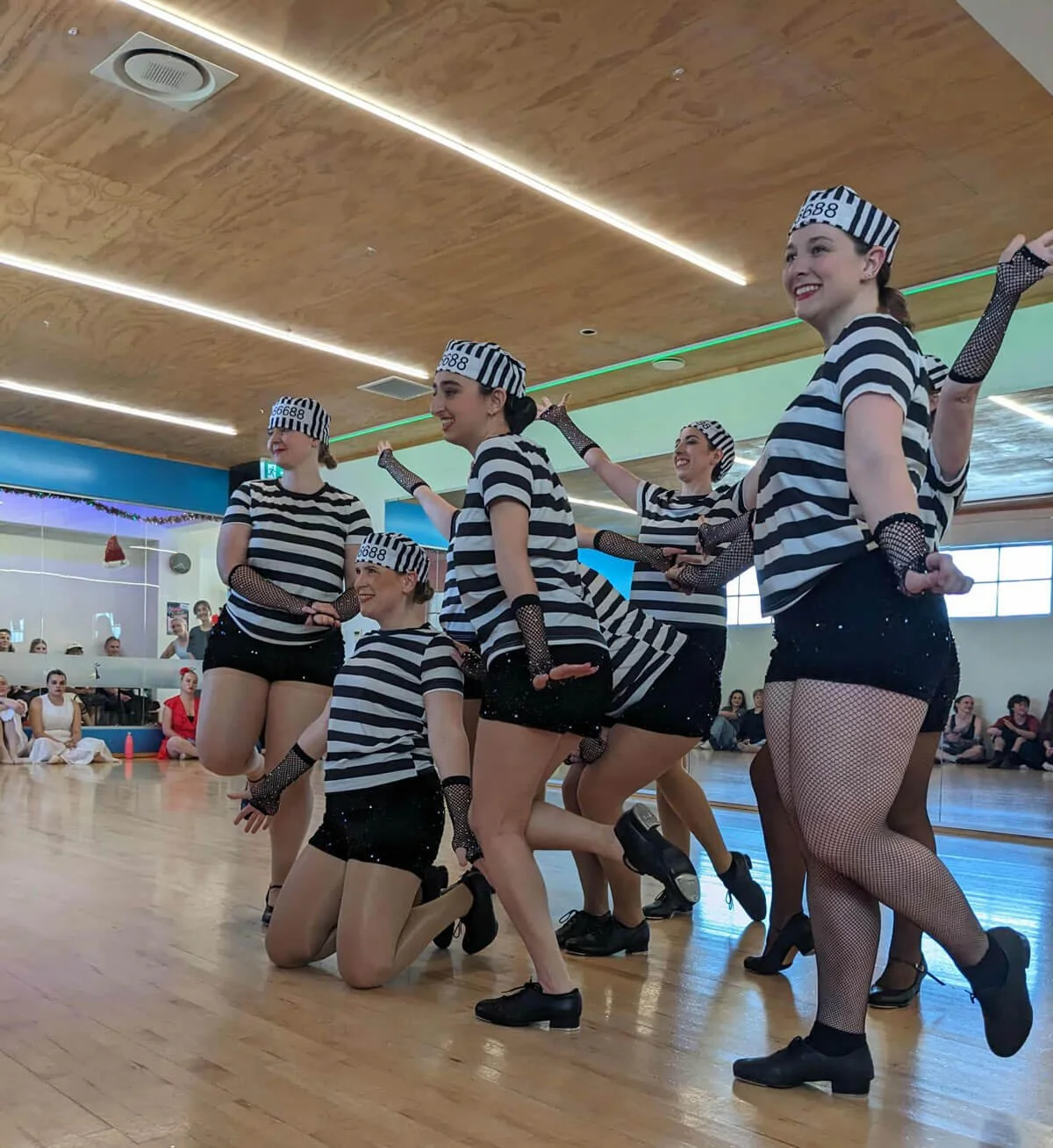 Dancers in striped costumes, posing as a group