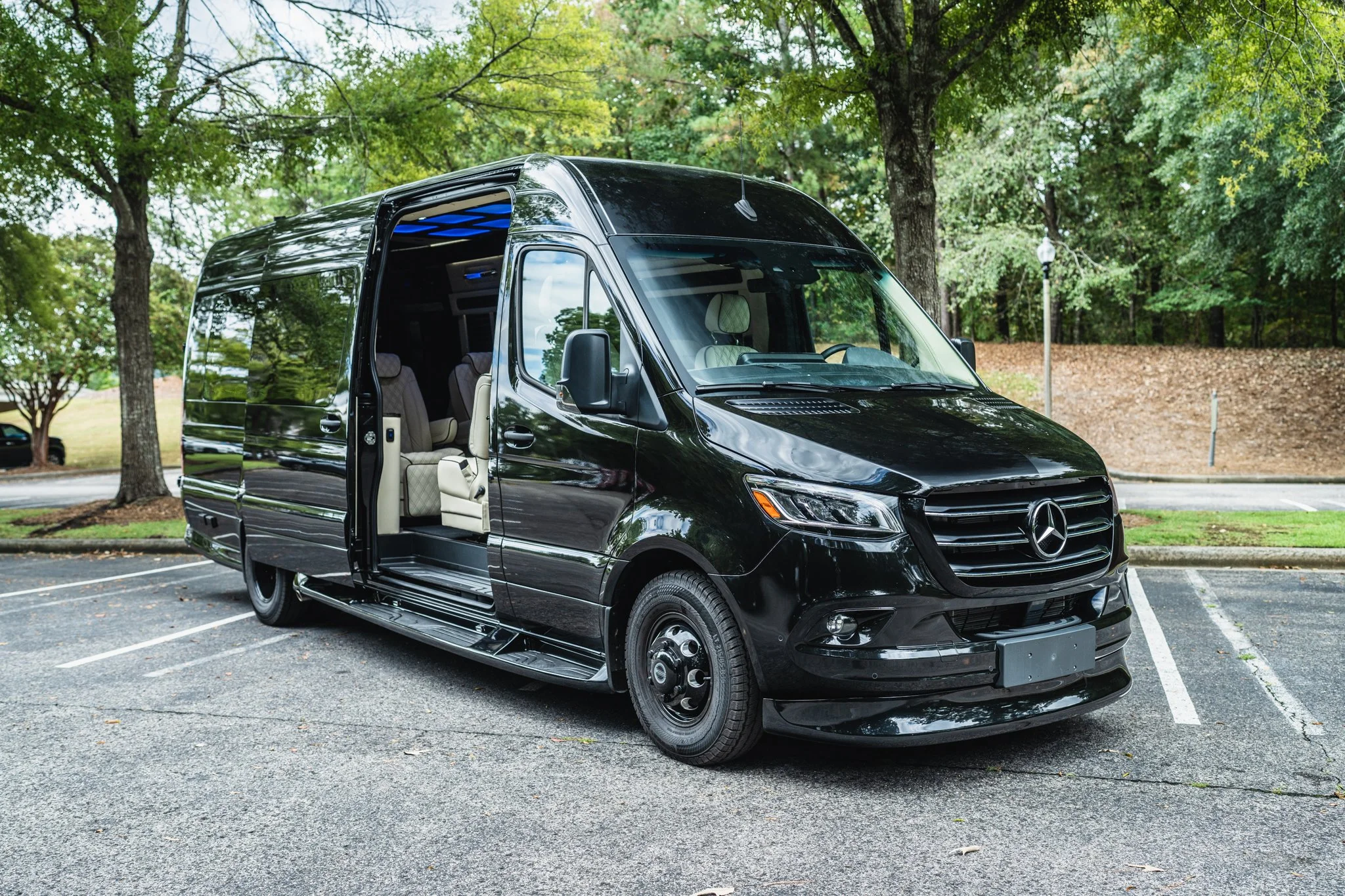 Black Mercedes Sprinter van exterior with blue LED interior lighting — Van Go Luxe Birmingham