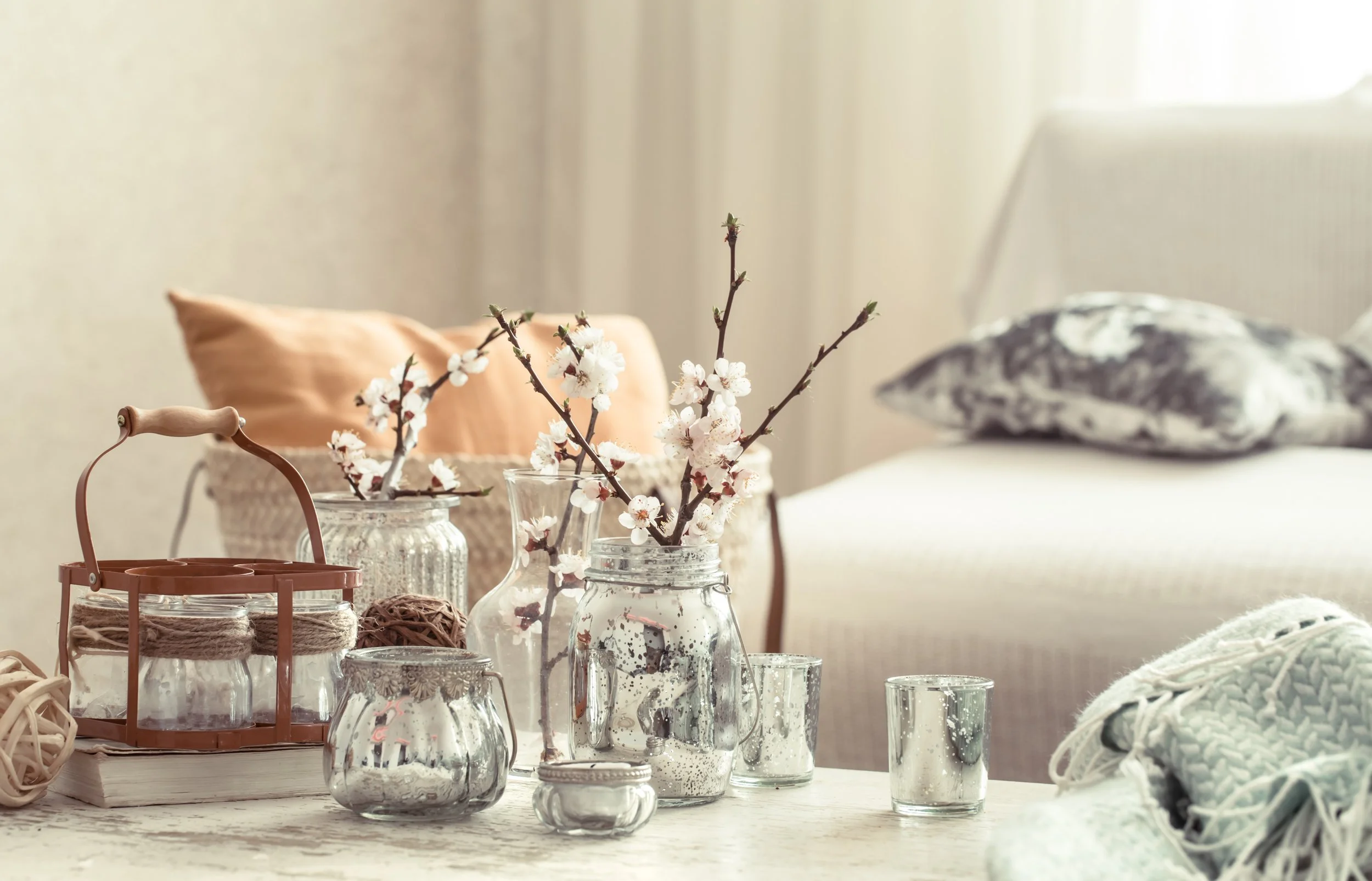 Soft living room scene with glass jars and a knit throw -- cozy, calm aesthetic.