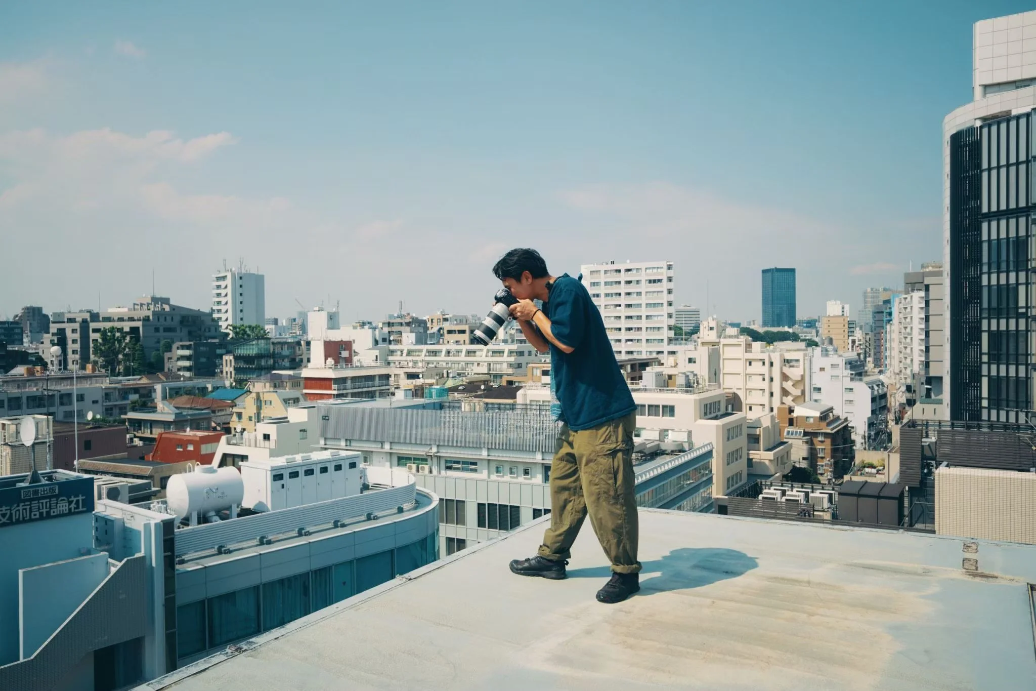 都市の屋上でカメラを構える男性