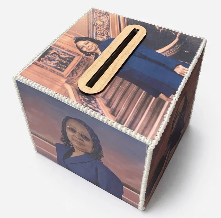 Decorative card/money box cover with a printing of a woman in a blue blazer on it.