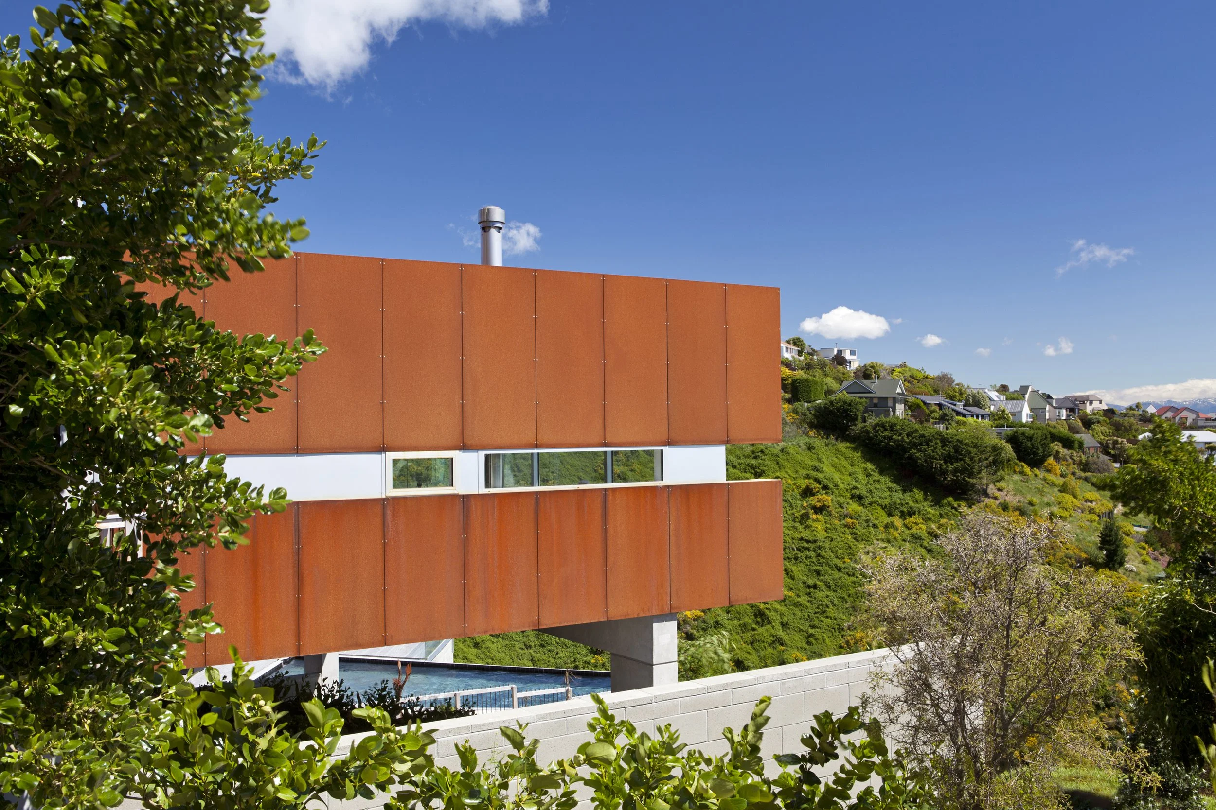 Redcliffs Cor-Ten House – Christchurch coastal home in weathered steel with expansive glazing by AW Architects (2012).