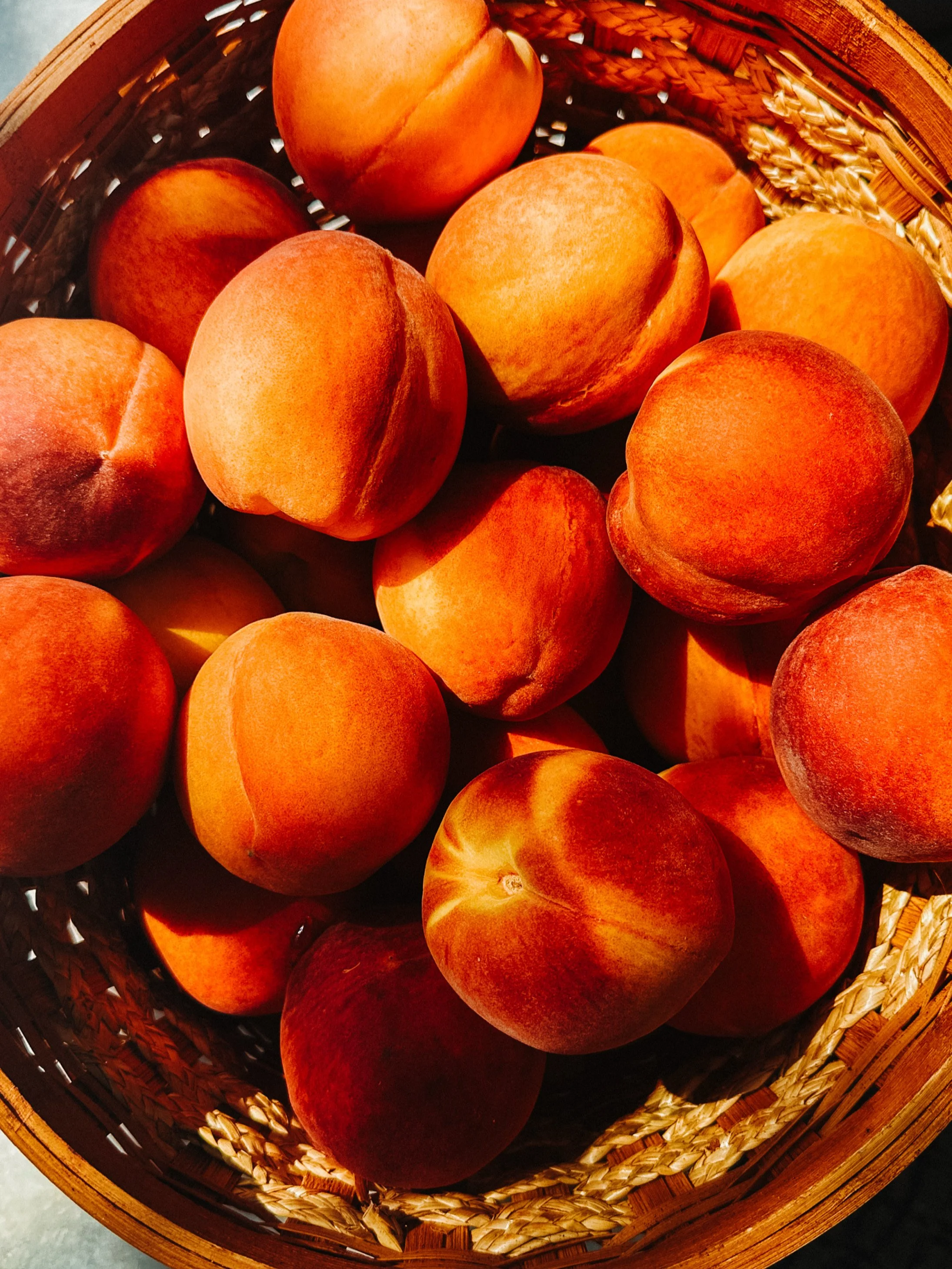 A basket filled with ripe, orange peaches.