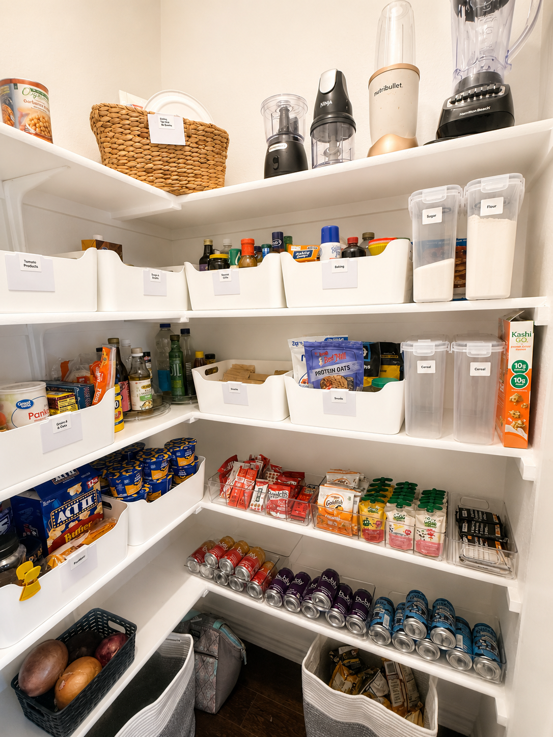 A well-organized pantry with various food and kitchen items, including canned goods, bottles, boxes, and containers labeled with items like sugar, flour, cereal, and spices.