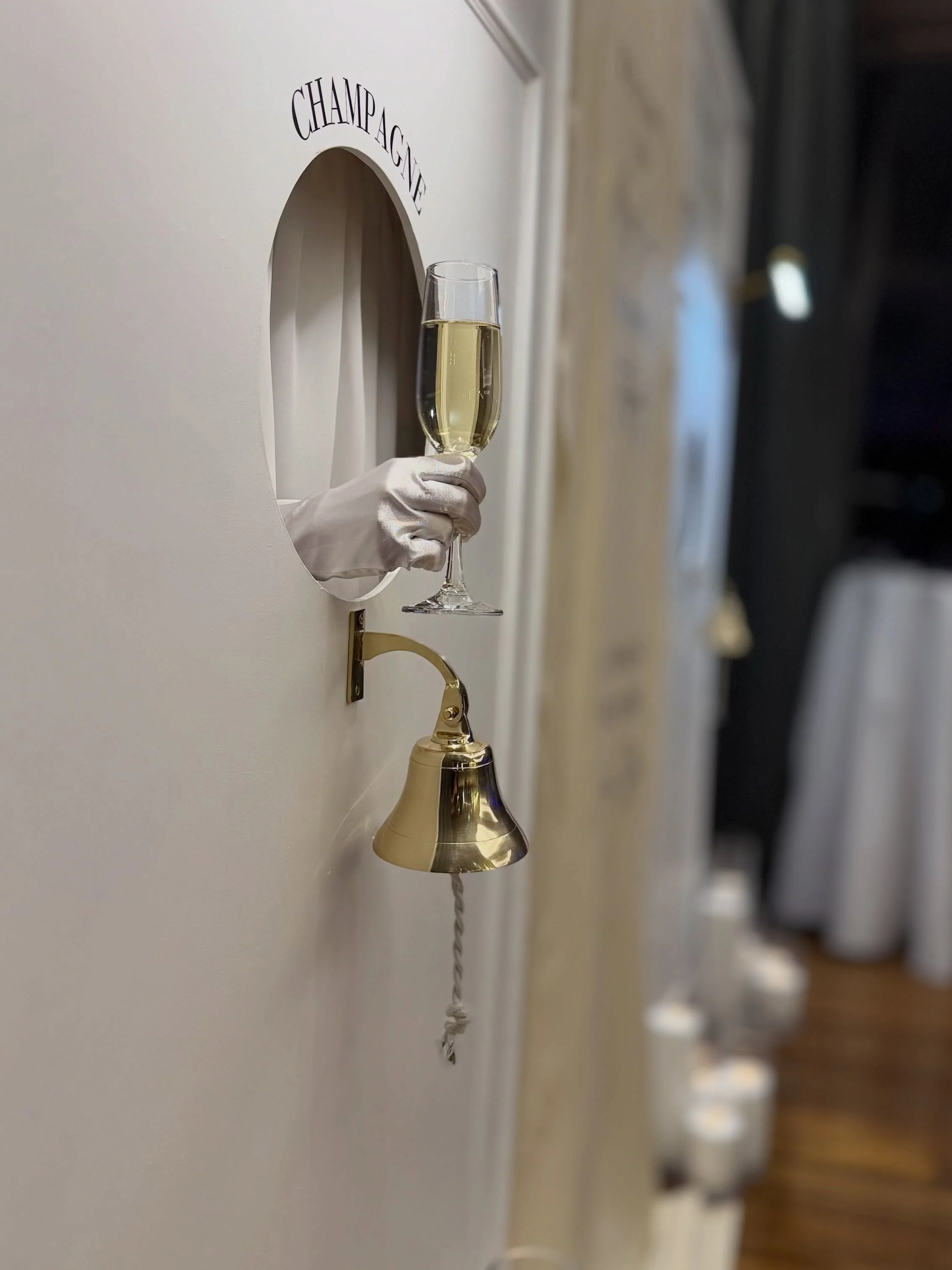 Ring for Champagne. 
Give your guests an experience they won&rsquo;t stop talking about.
Touch the bell, ring for your glass, and let the luxury come to you. Our interactive white-and-gold Sip Wall brings instant glamour, charm, and pure fun to every