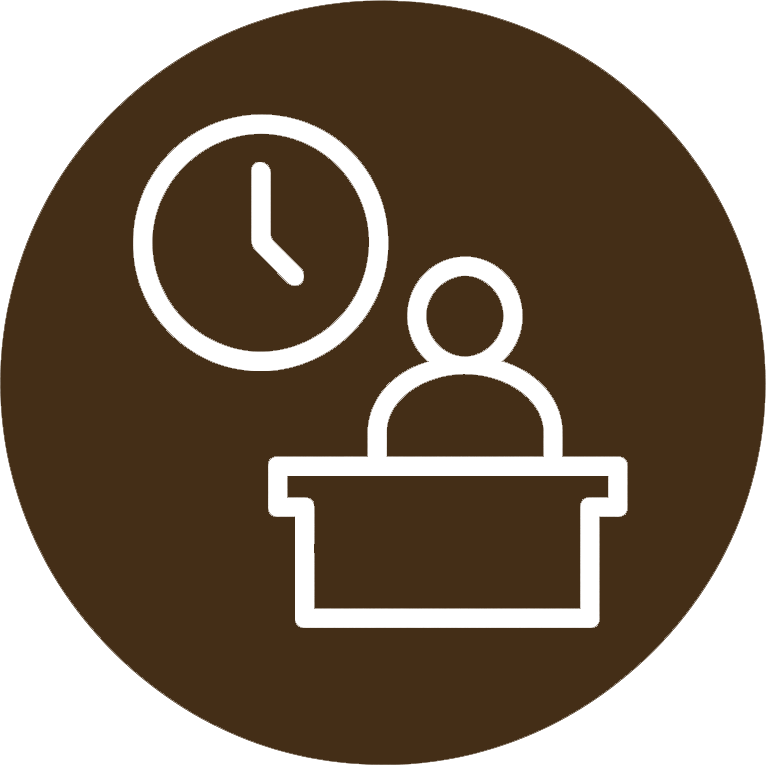 Icon of a person sitting at a desk with a clock on the wall behind them.