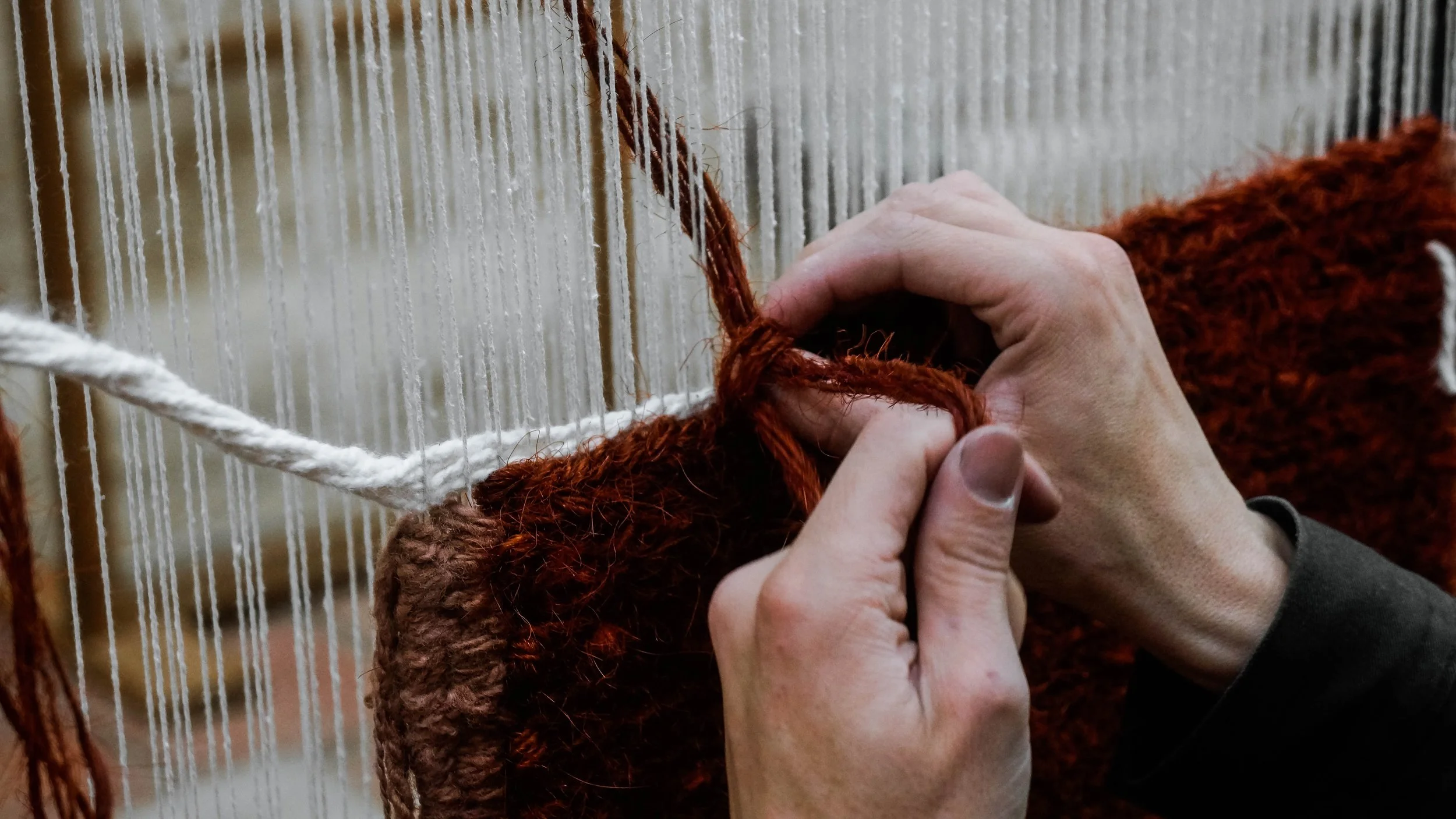 manos trabajando en telar de marco anudado