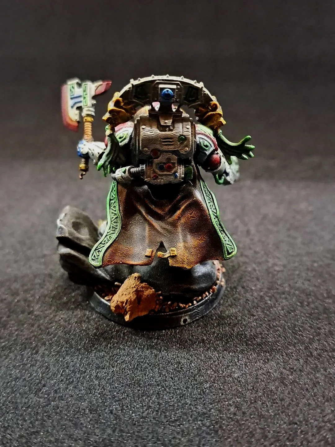 Kunststofffigur eines Sci-Fi-Charakters, der eine Rüstung und ein Cape trägt, bewaffnet mit einer Waffe, auf einer schwarzen Oberfläche