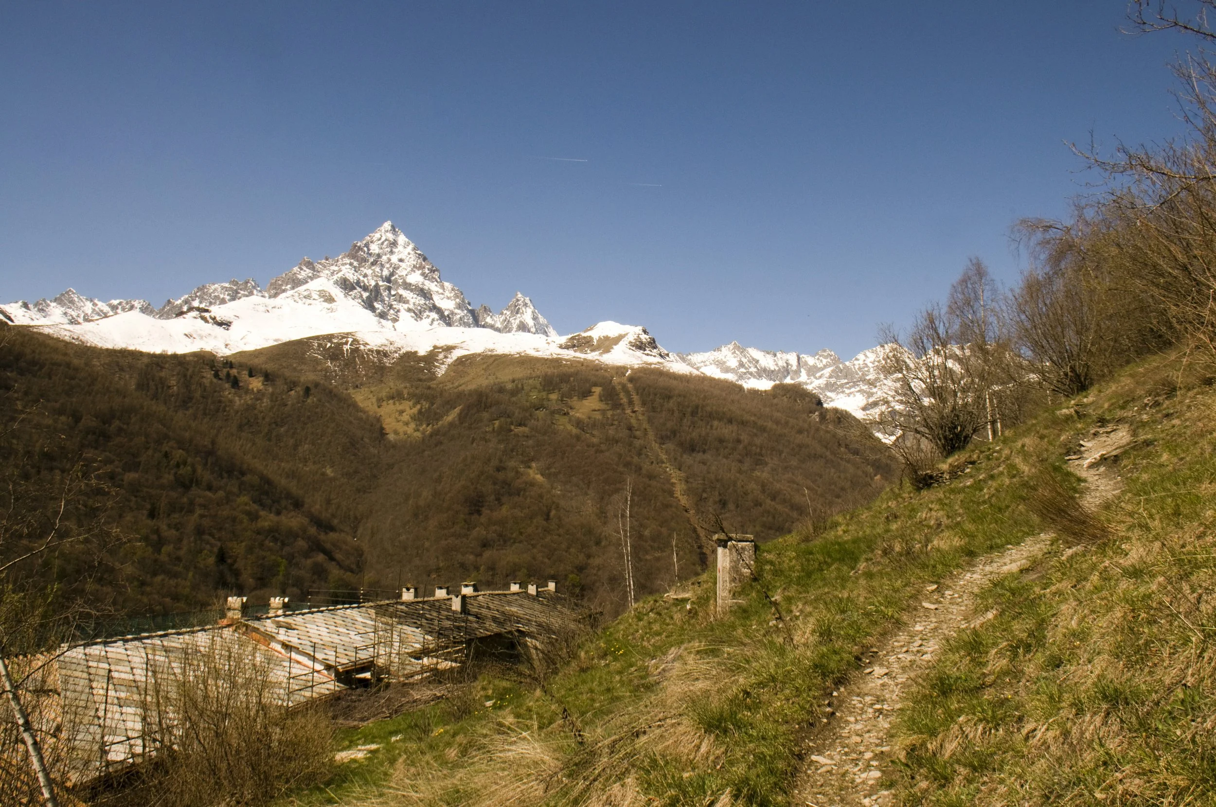 Sul sentiero che dal Santuario di San Chiaffredo conduce alla frazione Borgo. Ben visibile il Re di Pietra, il Monviso (3841 m).