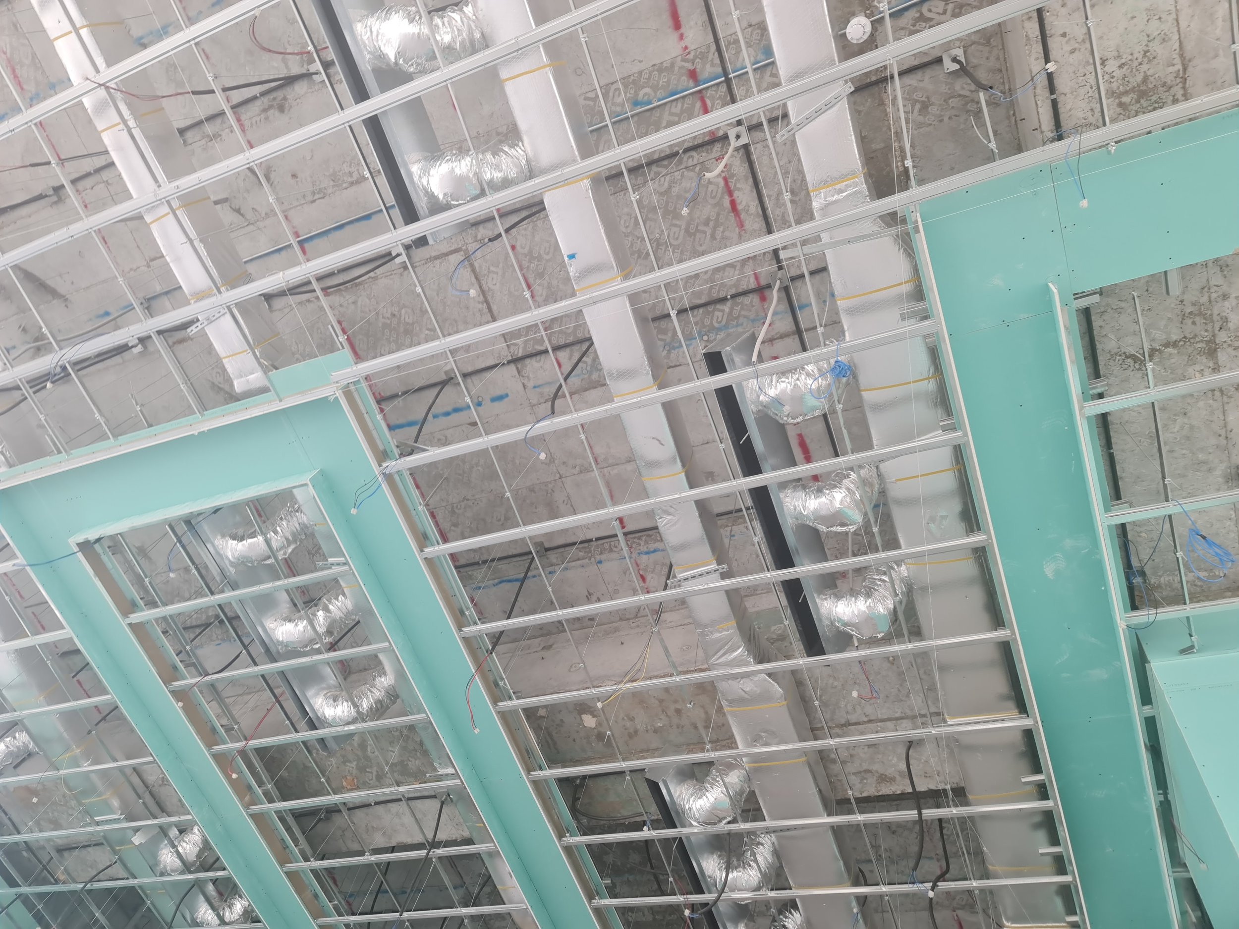 Construction site with metal framing and ductwork for HVAC system.