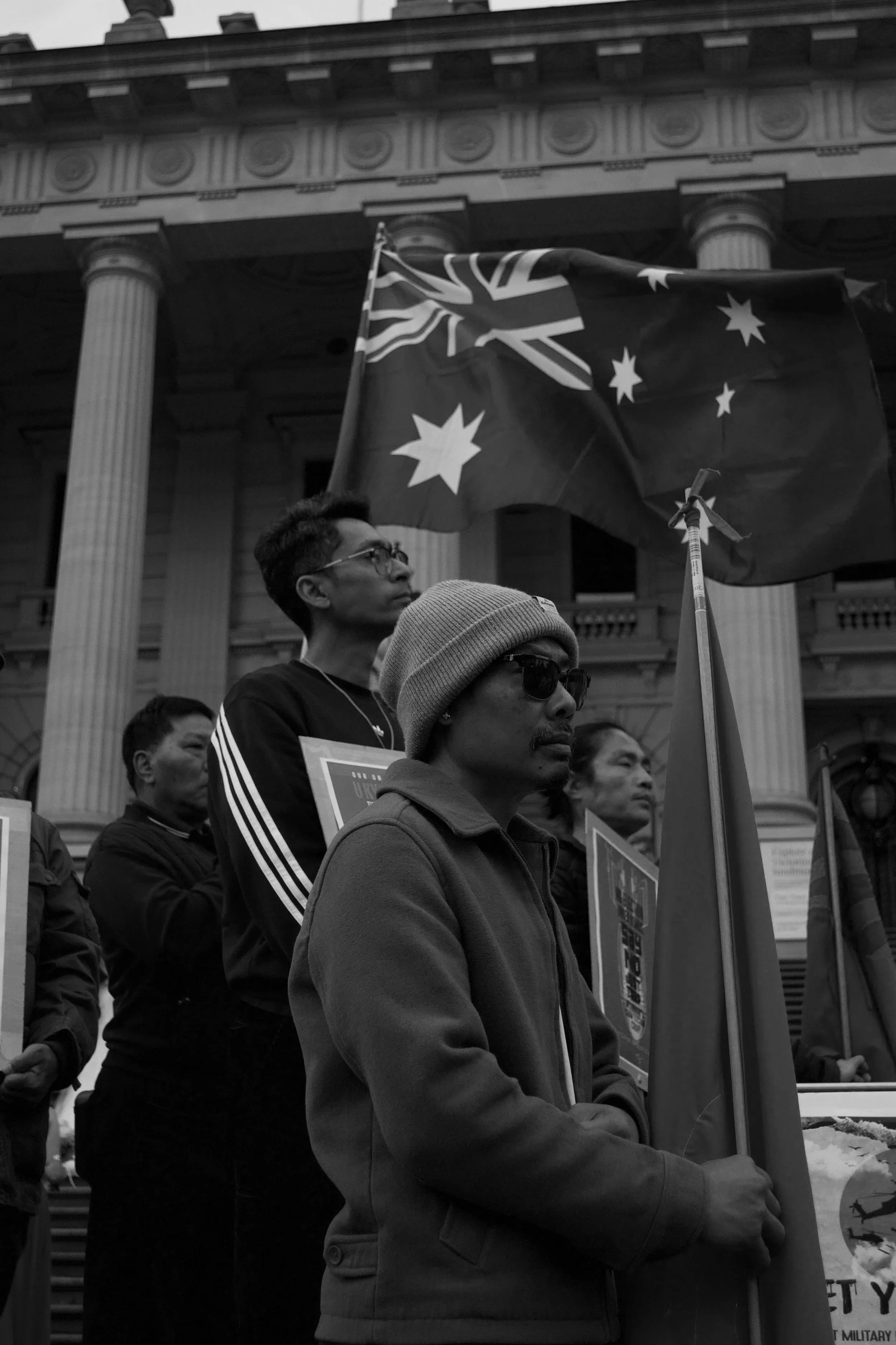 A protester holding the National League for Democracy (NLD) stands in front of another holding the Australian flag 06.09.2025