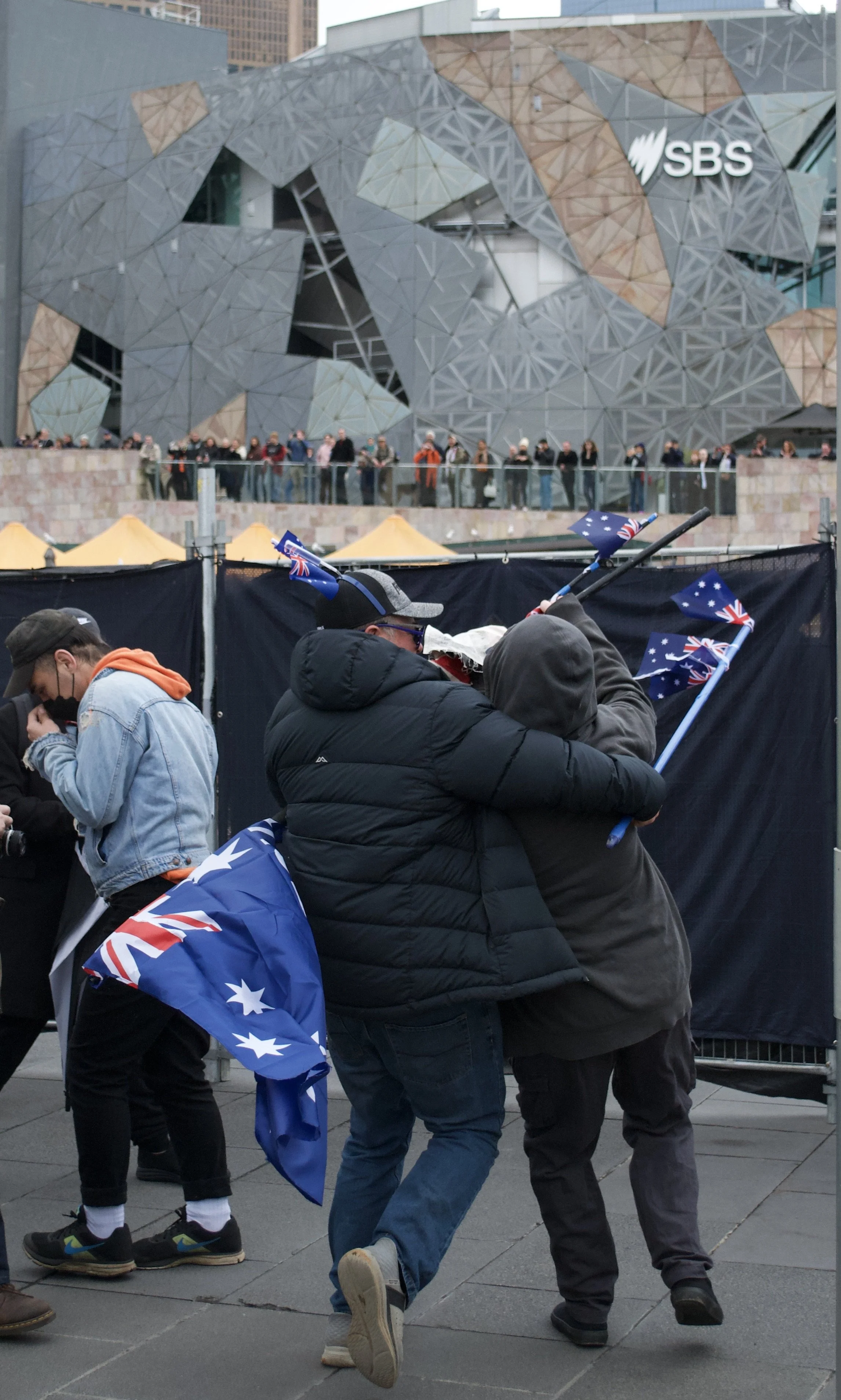 A 'March for Australia' protester grabs a counter protester after they took their flag in front of Fed Square
