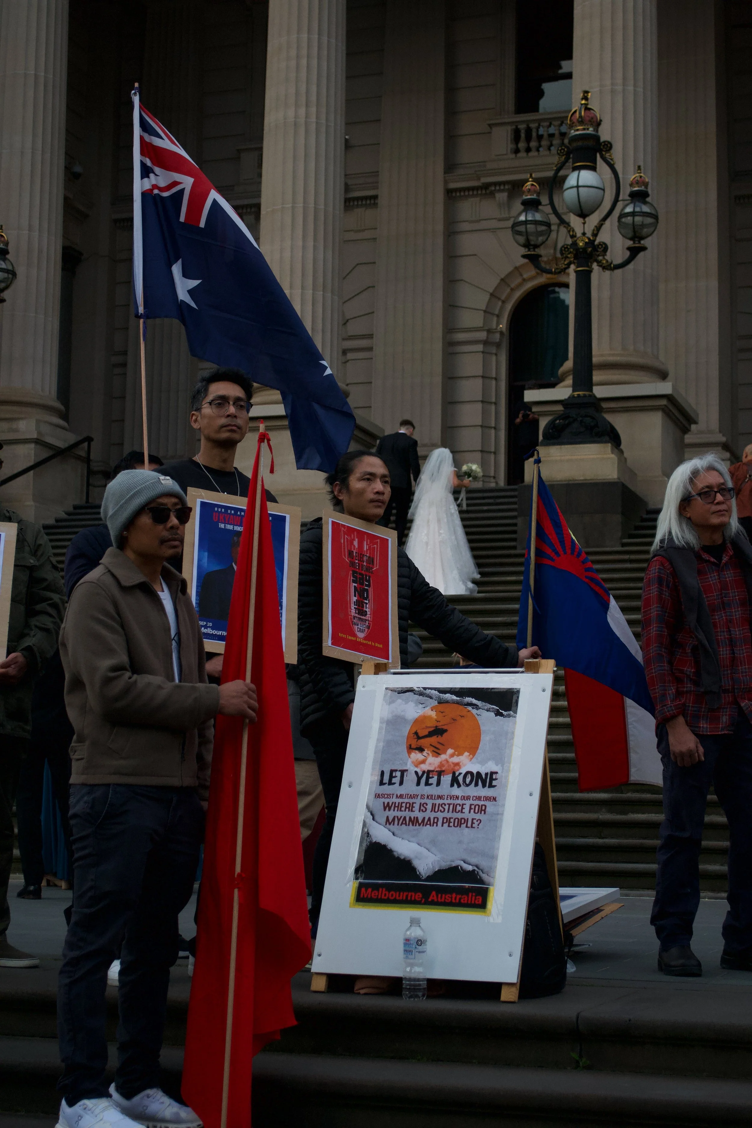 Protesters listen to a speaker whilst holding the NLD, Australian and Karen National Union flags 06.09.2025