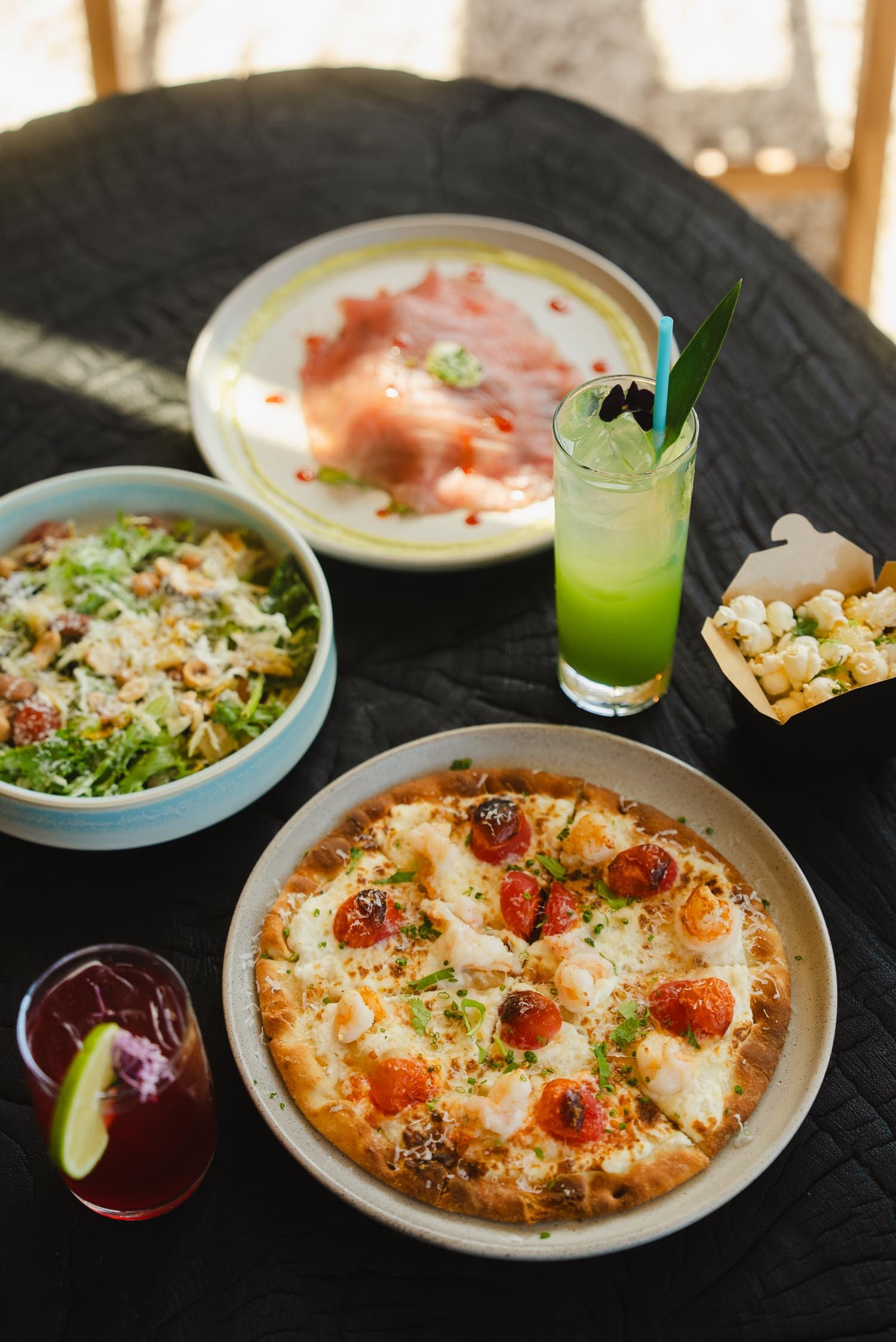 Dinner table with pizza, salad, and apres surf dishes at The Sitio Atlantic Park
