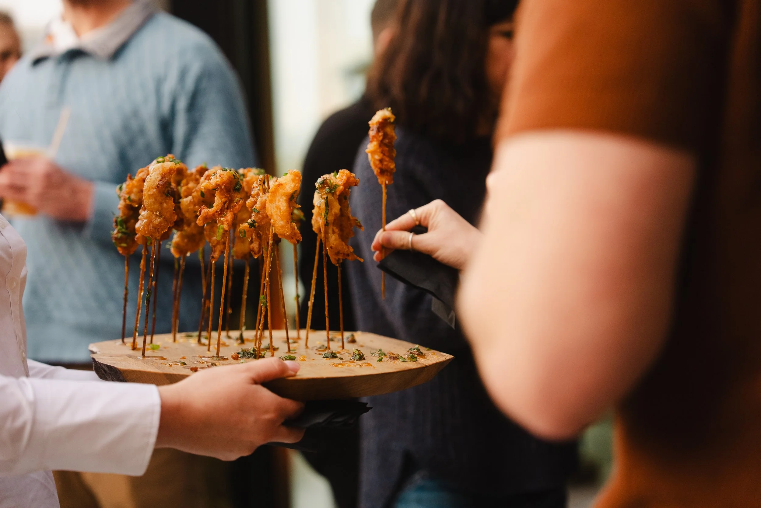 Guests sharing appetizers at an Atlantic Park restaurant, one of the many things to do in Virginia Beach near The Sitio