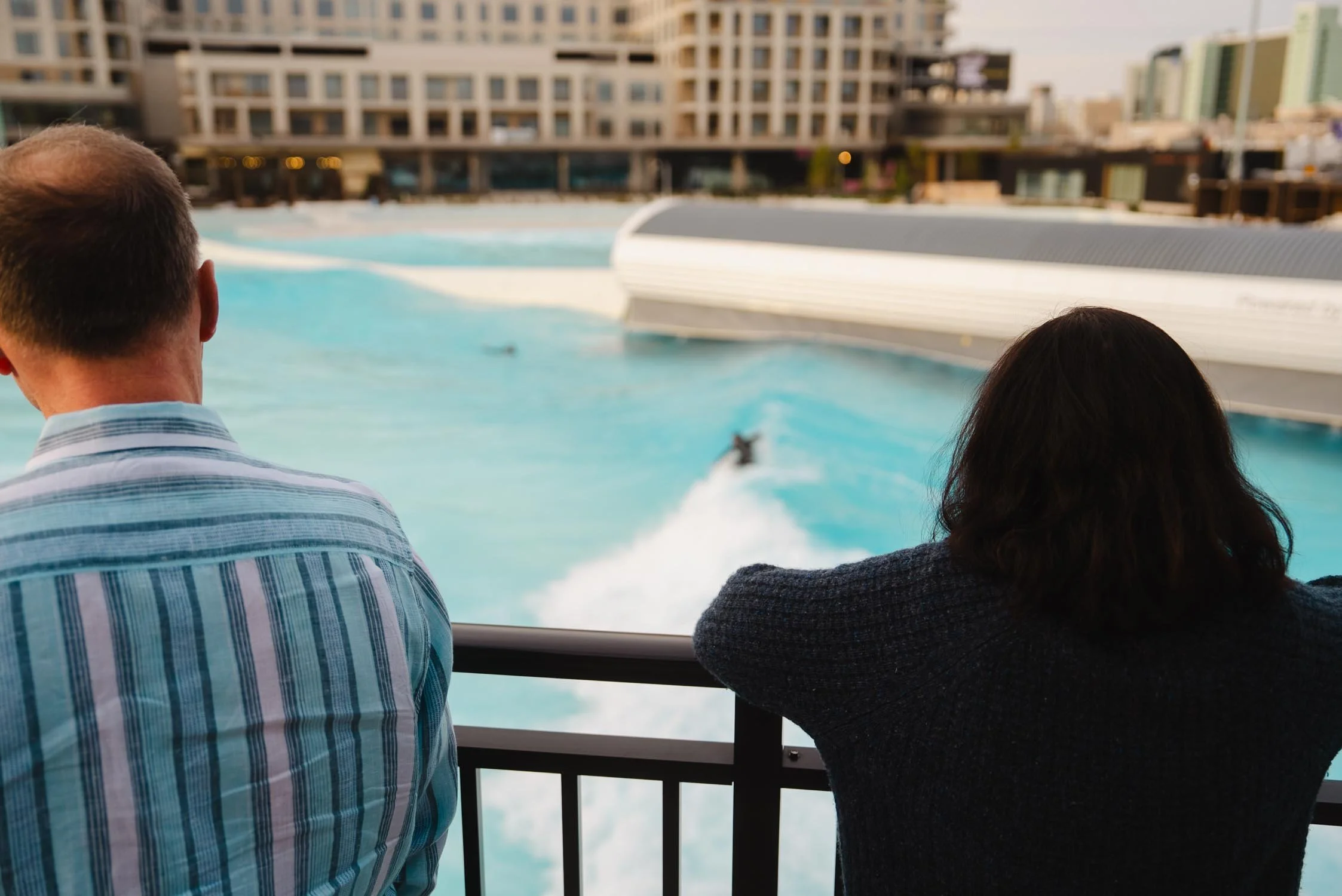 Guests watching surfers at Atlantic Park Surf from The Sitio balcony during a stay near Atlantic Park Surf