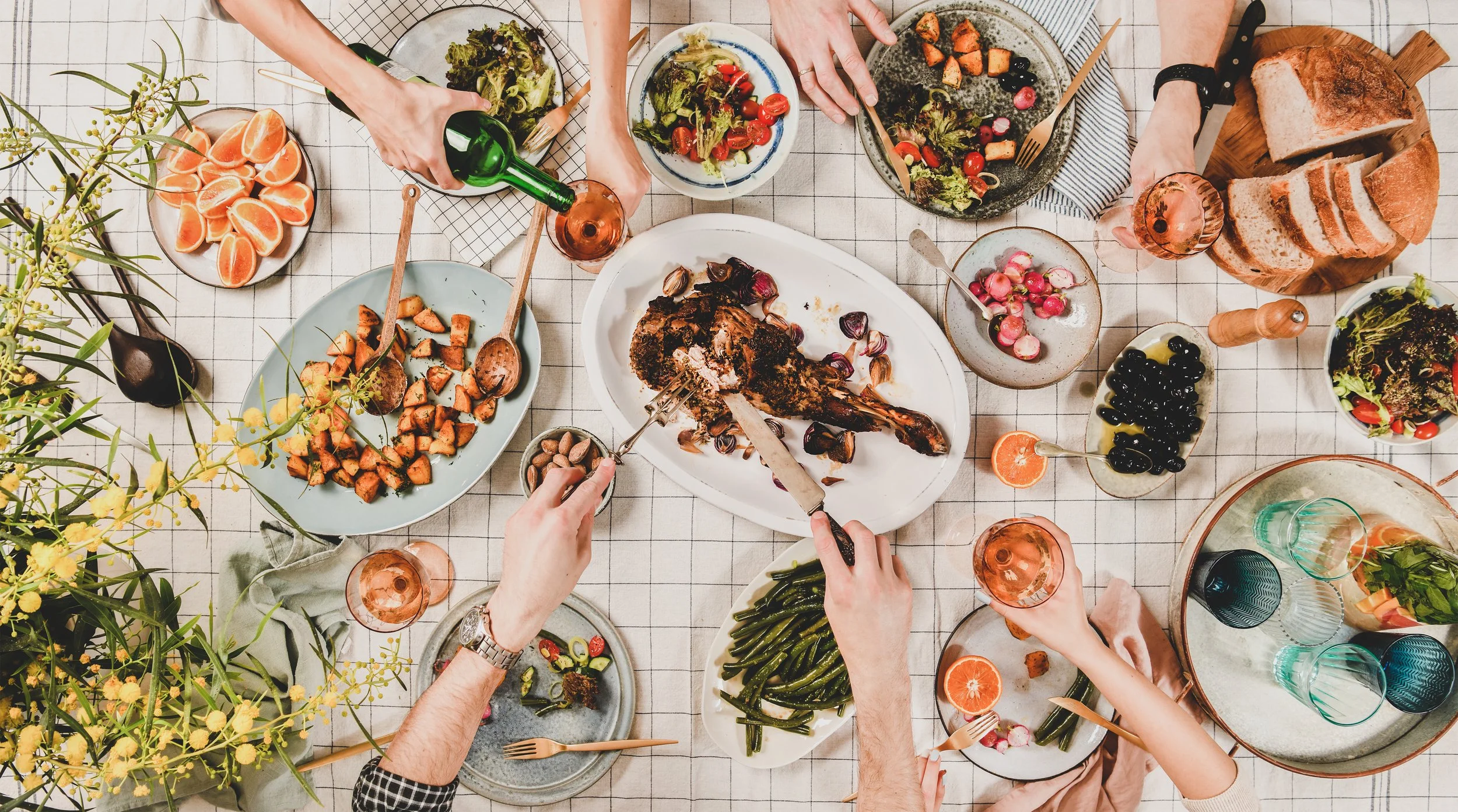 People sharing a family-style meal at a restaurant near The Sitio in Atlantic Park, Virginia Beach