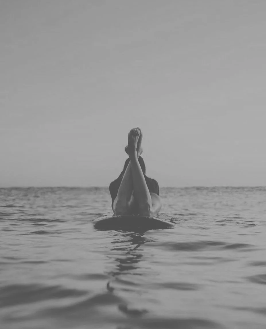 Person resting on a surfboard in the Atlantic Ocean during a stay near Atlantic Park Surf
