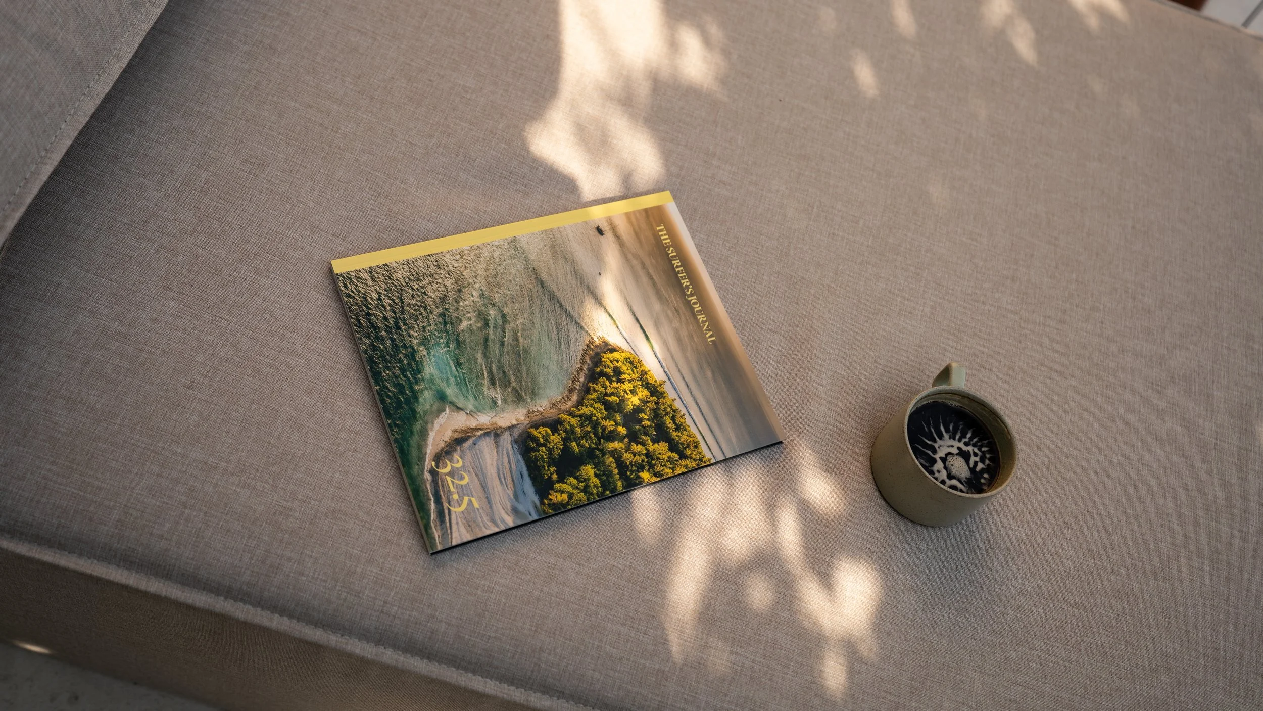 Beach photography book beside a coffee mug at The Sitio, a hotel near Atlantic Park Surf in Virginia Beach