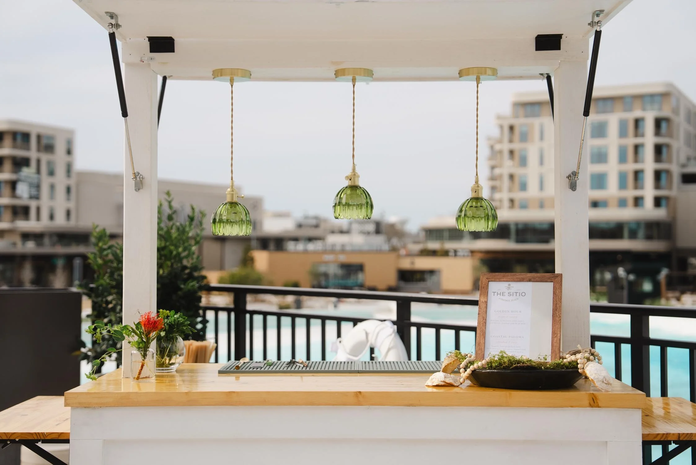 Outdoor bar with pendant lighting overlooking the pool at The Sitio Atlantic Park
