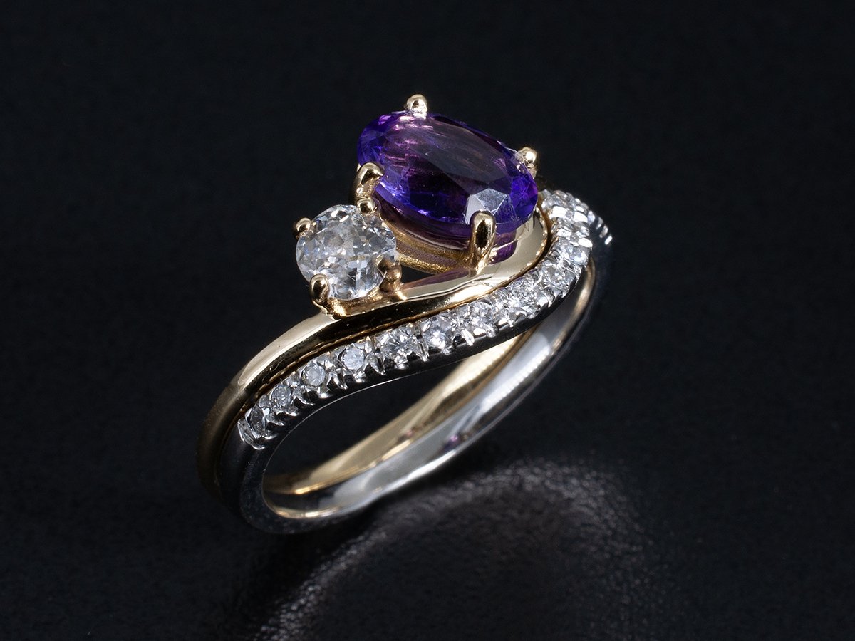 A bespoke engagement ring featuring an unheated tanzanite centre stone set in platinum with diamond pavé surround