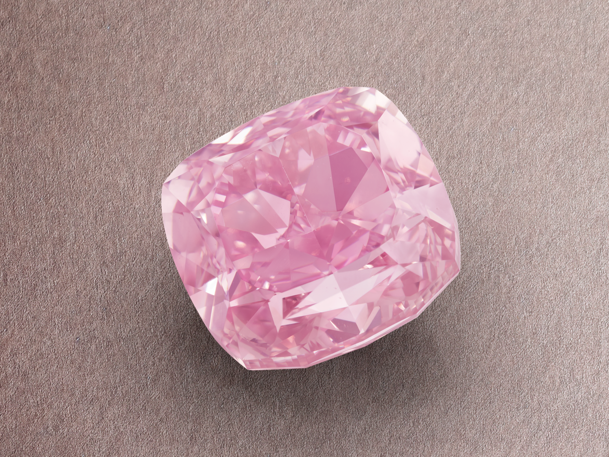 Close-up view of Phillips Lot 416, a 6.95-carat Fancy Vivid Purplish Pink diamond from The Geneva Jewels Auction V, showing its cushion modified brilliant cut and intense colour saturation.