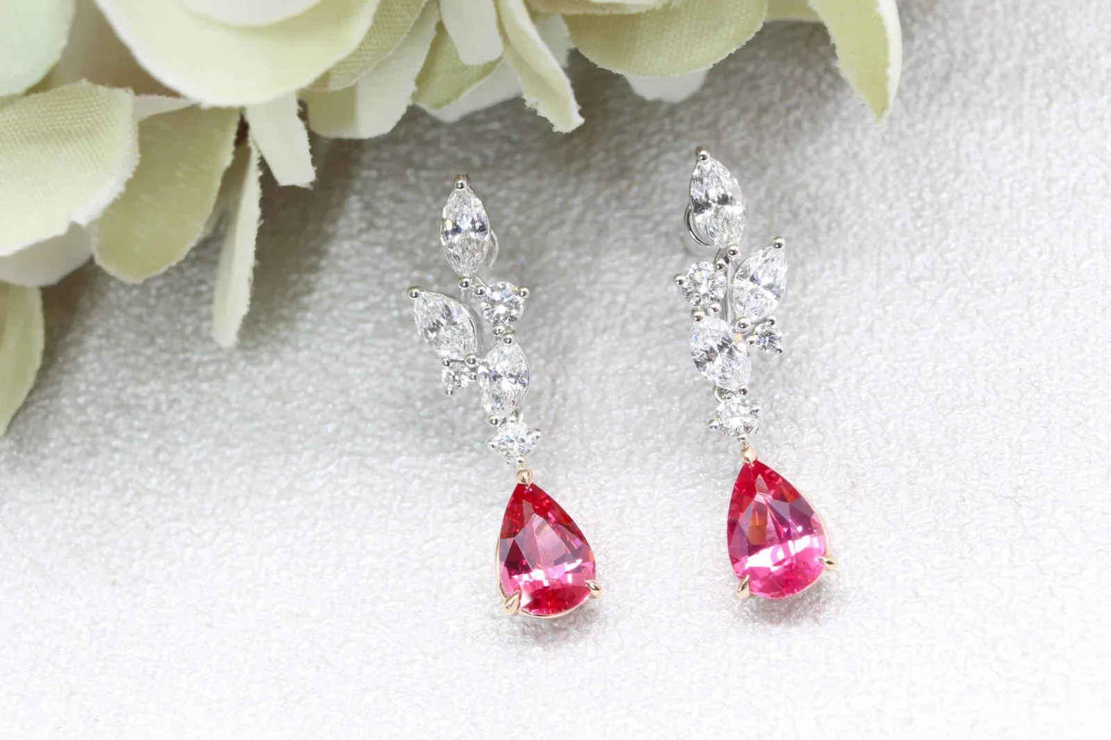 High jewellery earring featuring pear shape colourless diamonds and vivid pink Mahenge spinels set in white gold.