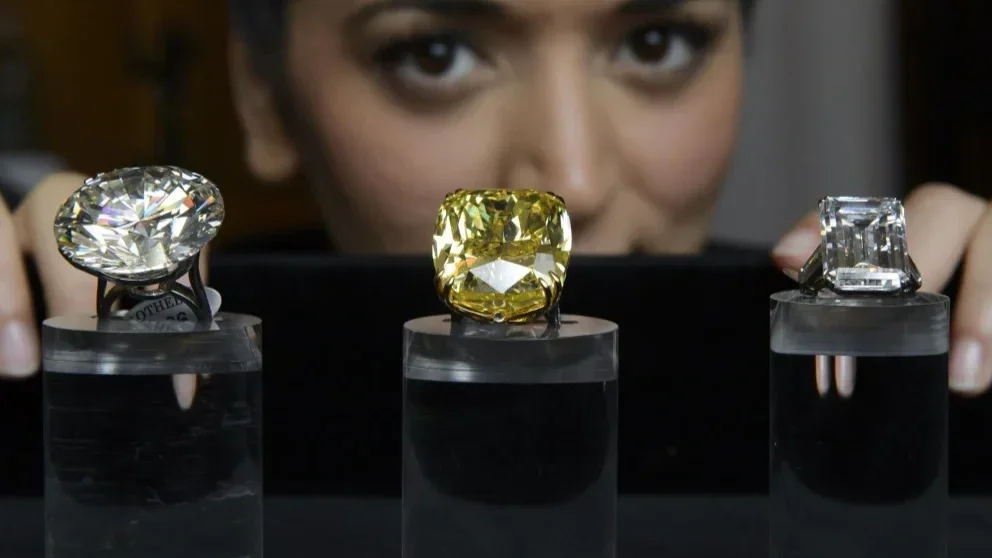 Exceptional fancy coloured diamond ring presented at a Sotheby’s auction, showcasing a rare vivid coloured diamond surrounded by white diamonds in a high jewellery setting.