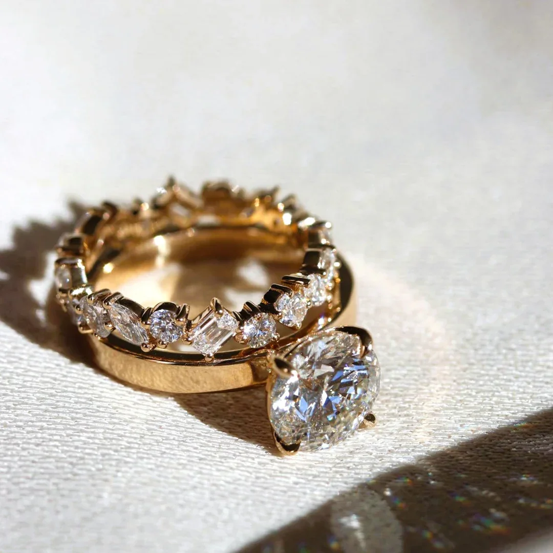 A handcrafted platinum solitaire engagement ring with a round brilliant diamond, knife-edge shank and hand-engraved milgrain detail