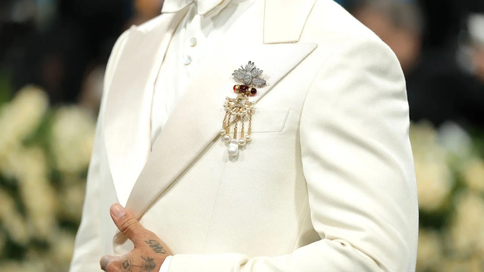 Lewis Hamilton wearing a bespoke suit accented with a vintage brooch at the Met Gala, blending classic tailoring with contemporary men’s jewellery expression.