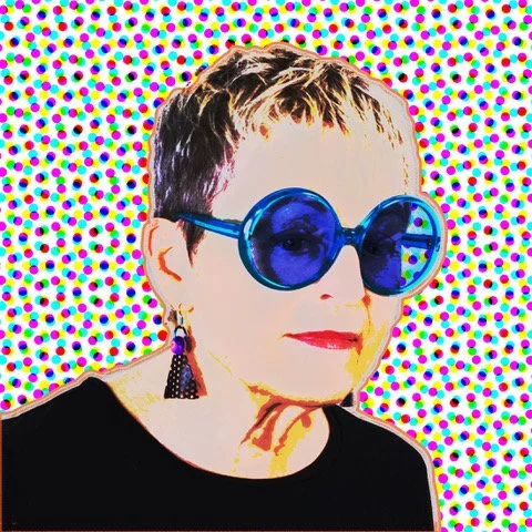 Portrait of a woman wearing large blue sunglasses, earrings, and a black top, with a colorful dotted background.