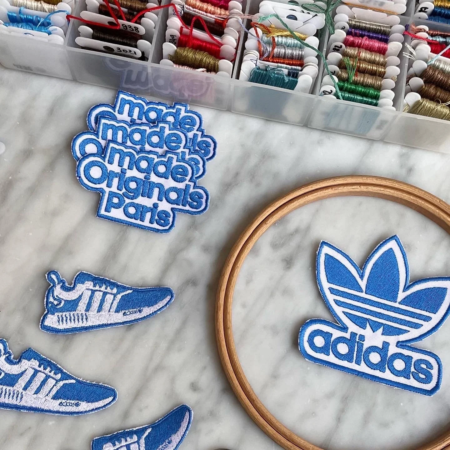 Collaboration avec Adidas : création de patchs brodés exclusifs pour un événement en boutique. Une série imaginée par Eva Bromberg mêlant design sportif et artisanat textile, symbole du savoir-faire créatif du studio à Paris.