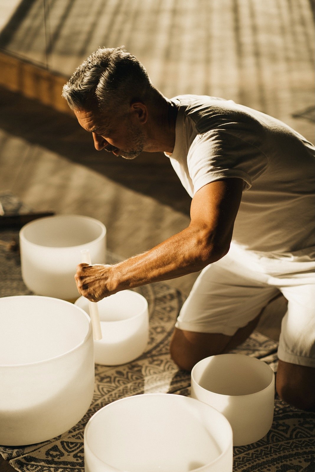 Rob Sykes sound therapist playing several quartz crystal singing bowls at wellness resort acro suites in crete