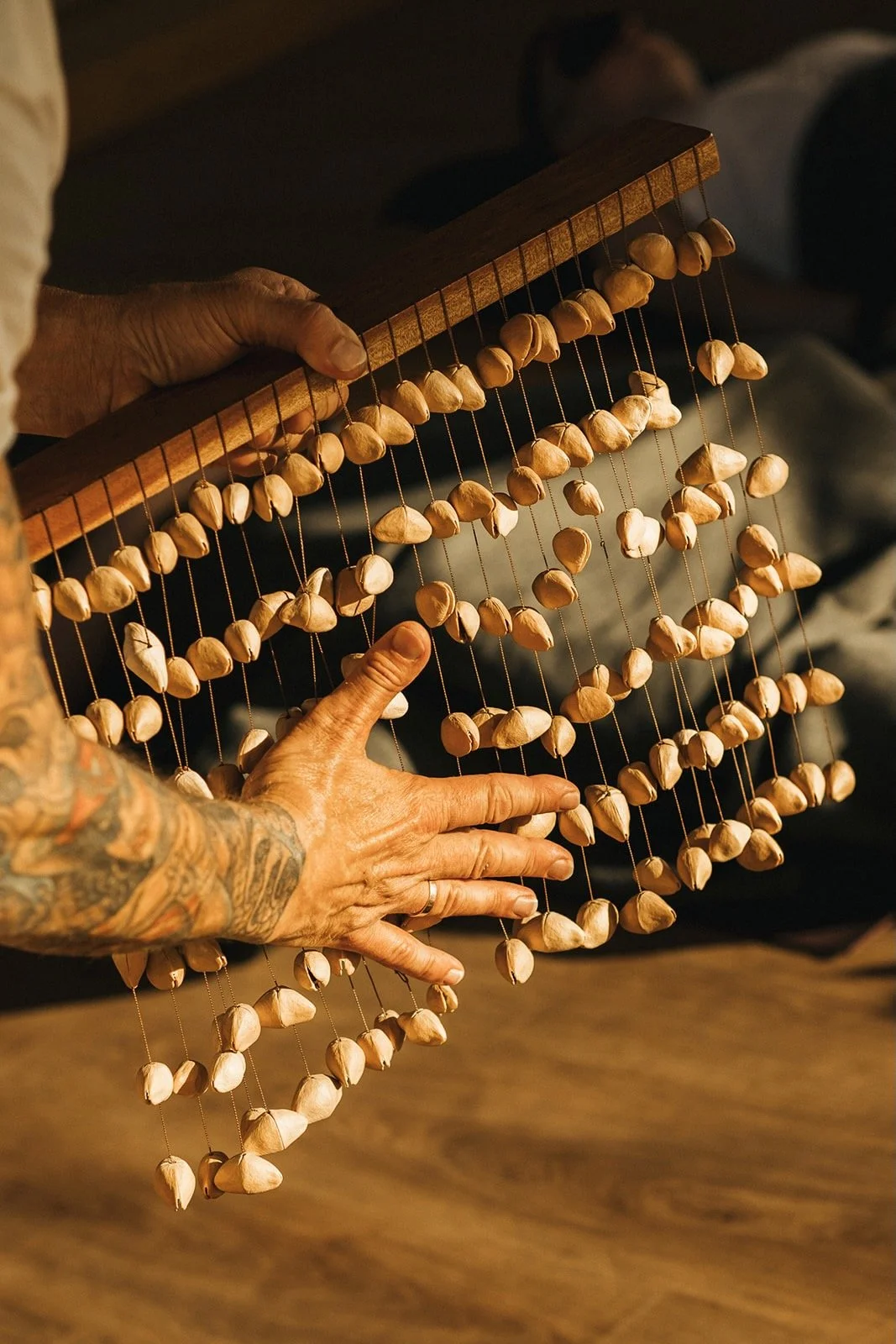 rob sykes sound therapist playing a rain chime instrument at a sound journey at wellness resort Acro Suites in Crete