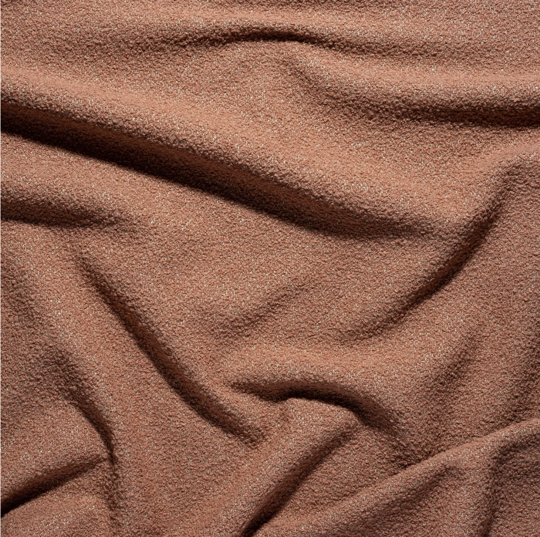 Close-up image of textured brown fabric with folds.