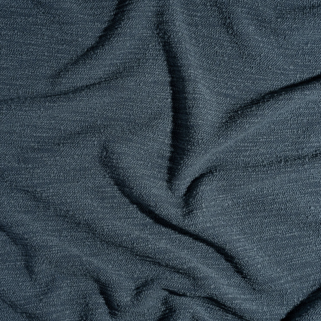 Close-up of textured dark fabric with folds and creases.