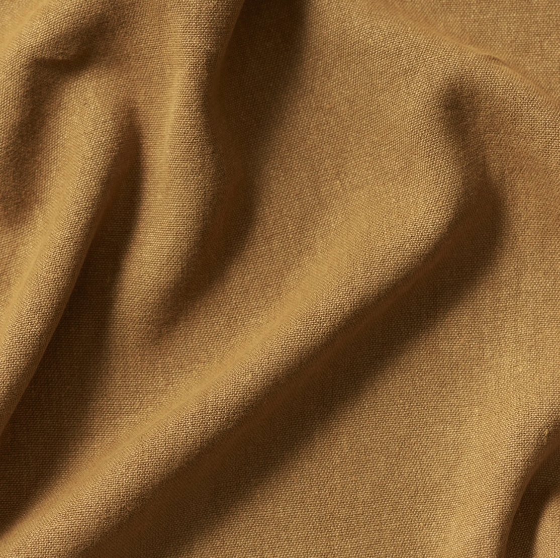 Close-up of brown fabric with creases and texture.