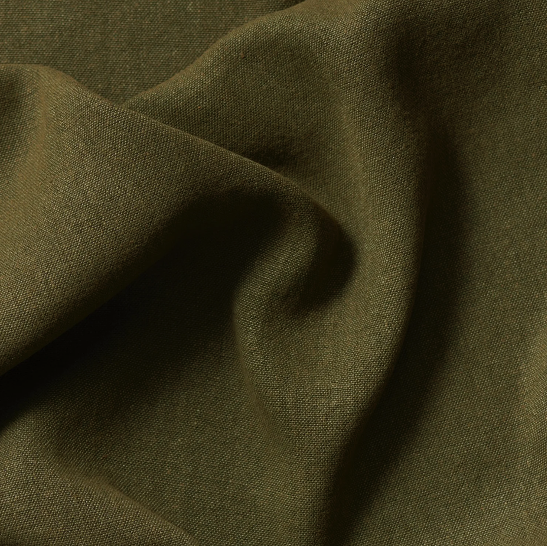 Close-up of olive green fabric with a slight fold.
