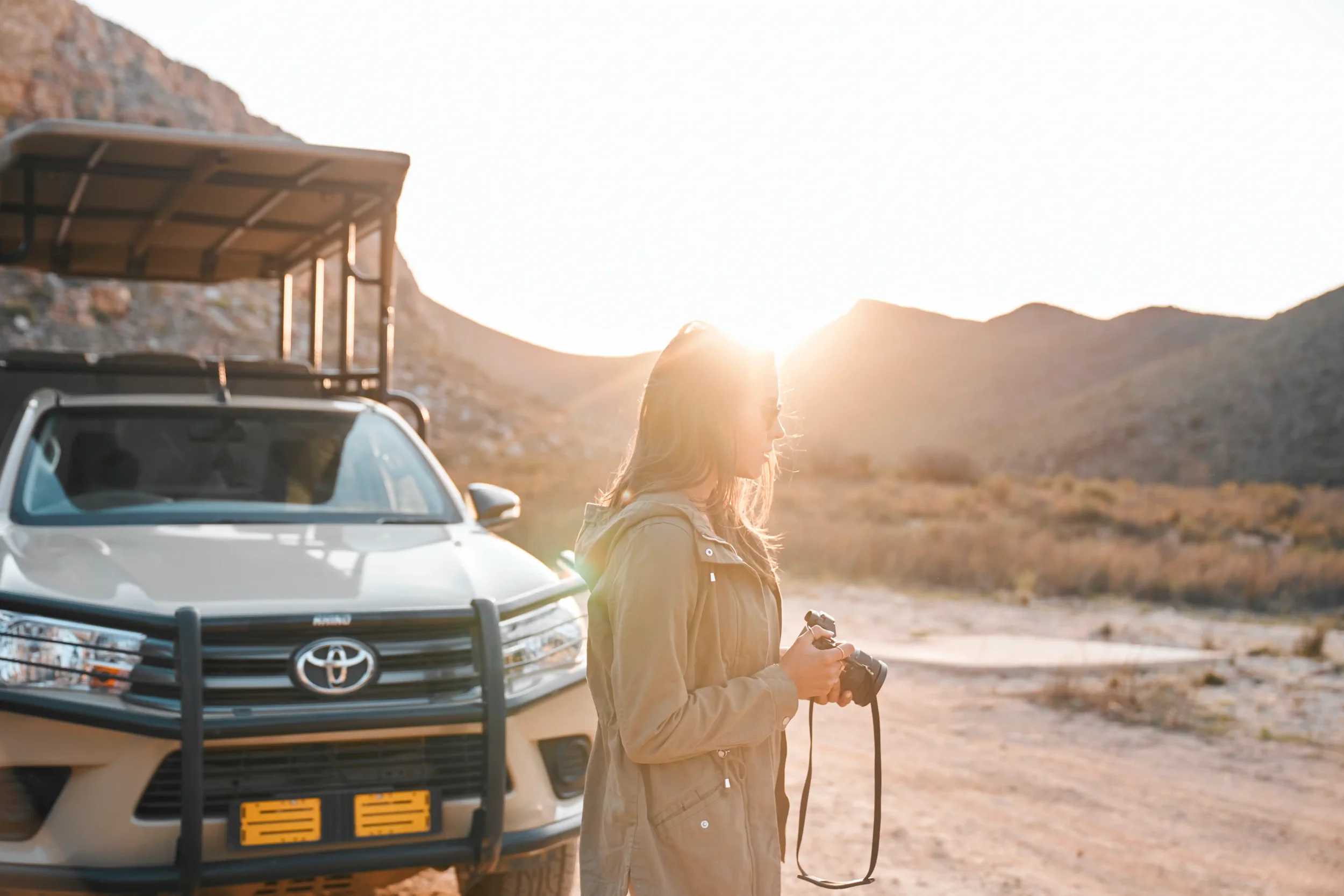 Femme photographe lors d'un shooting photo en safari en afrique du sud au coucher de soleil
