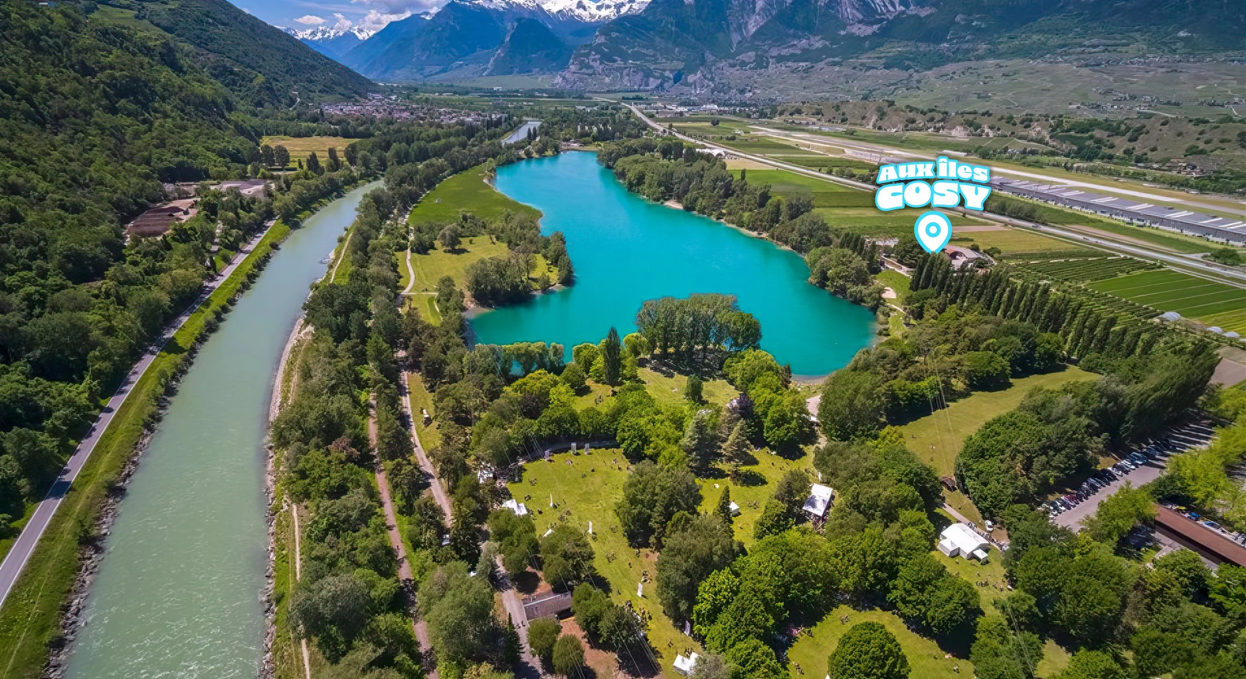 Vue aérienne du parc du Domaine des Îles (Sion, Valais, Suisse). Le lac et le Rhône dans une région verdoyante avec les alpes en arrière plan. Zone verte nature et agricole. Emplacement : 'Aux Îles Cosy'.